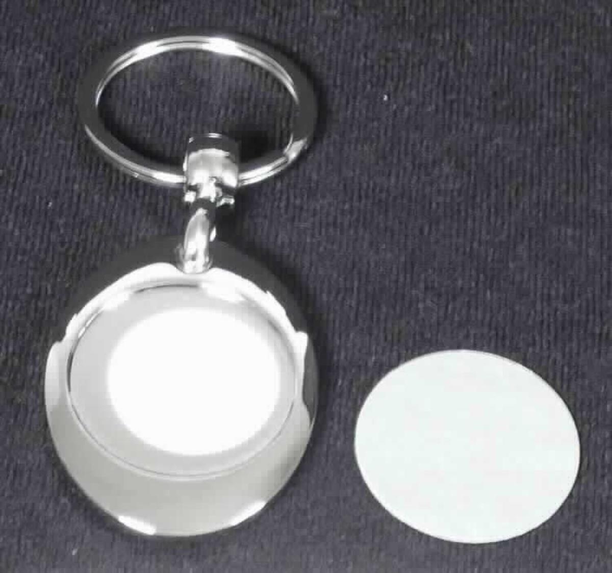 Es handelt sich um einen Schlüsselanhänger, bestehend aus einem annähernd ovalen Anhänger aus einer Zinklegierung mit gewichtsmäßig vorherrschendem Zinkgehalt, der durch ein Drehgelenk aus unedlem Metall an einem Schlüsselring aus Stahldraht befestigt ist. Der Anhänger ist auf der Rückseite mit einem Magneten ausgestattet, an dem ein runder, mit einer Gravur versehener Einkaufswagenchip aus Stahl befestigt ist. Auf der Vorderseite weist der Anhänger eine kreisrunde Aussparung mit einem passgenauen Einsatz aus Aluminium auf, der auf einer Seite mit einer fabigen Lackierung versehen und noch mit Fotos oder Ähnlichem bedruckt wird.
Der Schlüsselanhänger ist in einer Pappschachtel verpackt. 

Zink herrscht gegenüber jedem anderen unedlen Metall gewichtsmäßig vor. Eine Einreihung in die Position 7326 ist damit ausgeschlossen.

Abbildung siehe Anlage.

Derartige Erzeugnisse gehören als "andere Waren aus Zink" zur Codenummer 7907 0000 00 0 des Zolltarifs.