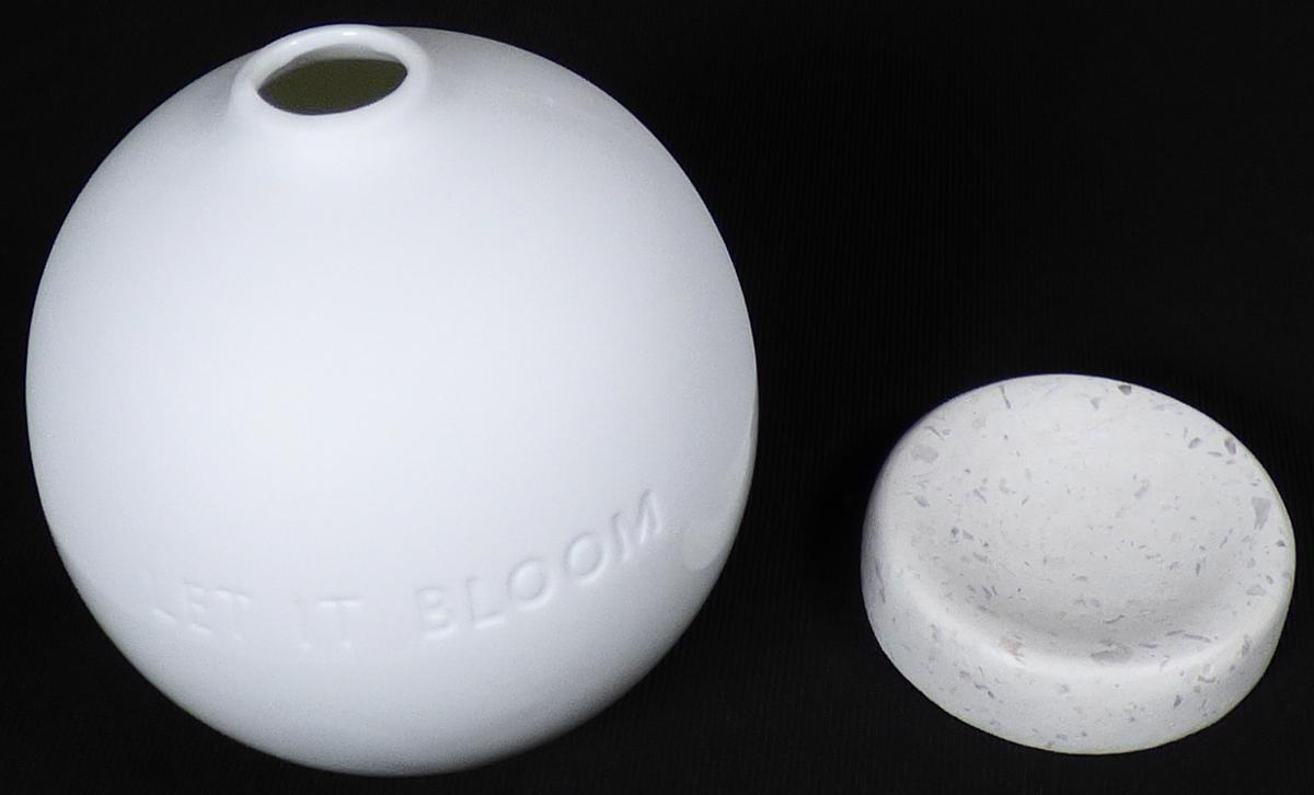 Keramischer Ziergegenstand (Vase), Foto siehe Anlage,
- in Form einer zusammengesetzten Ware, bestehend aus:
- einem keramischen Ziergegenstand (Vase):
- - in Form einer weißen, zur Hälfte glasierten, kugelförmigen Vase mit einer kleinen Öffnung
    (Durchmesser: ca. 1,5 cm); mit dem Schriftzug "LET IT BLOOM" versehen,
- - keramisches Erzeugnis, nach der Formgebung gebrannt, tonmineralhaltiges Material
    enthaltend,
- - lt. Antrag aus Porzellan,
- - ohne Hinweise auf Handarbeit,
- einer runden Halterung:
- - aus Kunststein (lt. Antrag Terrazzo),
 - - in den Abmessungen: ca. 5 cm (Durchmesser) x 1,5 cm (Höhe),
- - innen mit einer Vertiefung als Halterung für die Vase, die passgenau zum Einstellen der Vase
   gearbeitet ist,
- nach dem Umfang und der Bedeutung in Bezug auf die Verwendung verleiht die Vase aus
  Porzellan der zusammengesetzten Ware den wesentlichen Charakter.

"Keramischer Ziergegenstand (Vase), aus Porzellan, nicht handgearbeitet"