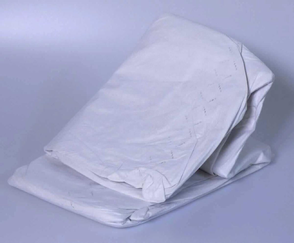 Es handelt sich um ein etwa ein 1,9 x 1,1 m großes, mehrlagiges Flächenerzeugnis mit folgendem Aufbau:

1. Außenlage aus Vliesstoff aus Chemiefasern.
2. Insgesamt vier Innenlagen aus Tissue-Papier.  
3. Außenlage aus Vliesstoff aus Chemiefasern.

Die Lagen sind im Randbereich miteinander verfestigt. Das Erzeugnis wird im Bereich des Rettungsdienstes und der Krankenpflege/Pflege als Einwegdecke zu hygienischen Zwecken verwendet. Es ist in einem bedruckten, klarsichtigen Kunststoffbeutel für den Einzelverkauf aufgemacht. 

Abbildung siehe Anlage.

Derartige Waren gehören als "Betttücher und ähnliche Waren zum Gebrauch im Krankenhaus oder zu hygienischen Zwecken, aus Papier oder Vliesen aus Zellstofffasern, in Aufmachung für den Einzelverkauf" zum TARIC-Code 4818 90 90 00, da es sich zolltarifrechtlich um eine aus verschiedenen Stoffen zusammengesetzte Ware handelt, deren wesentlicher Charakter nach dem Umfang sowie nach der Bedeutung für die Verwendung durch die Anteile aus Papier bestimmt wird.