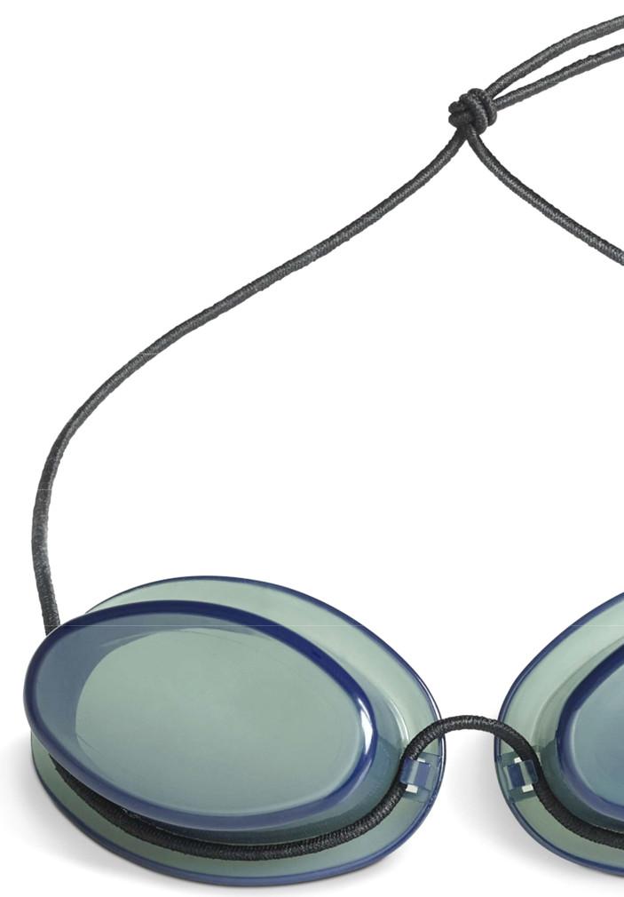 Sog. Schutzbrille, im Wesentlichen bestehend aus zwei einzelnen, ovalen, getönten Kunststoffgläsern, die auf der Innenseite über Auswölbungen verfügen, die das jeweilige Auge vollständig umschließen. Die Gläser sind mit einem Brillenband miteinander verbunden. Mit Hilfe des verstellbaren Brillenbands wird die Brille am Kopf befestigt (zur äußeren Form: siehe Abbildung in der Anlage).
Die Ware wird zum Schutz der Augen vor Strahlung bei Nutzung einer Infrarotlampe eingesetzt.
Die Ware wird als "Brille (Schutzbrille), andere als Sonnenbrillen, mit Brillengläsern aus Kunststoffen" eingereiht.