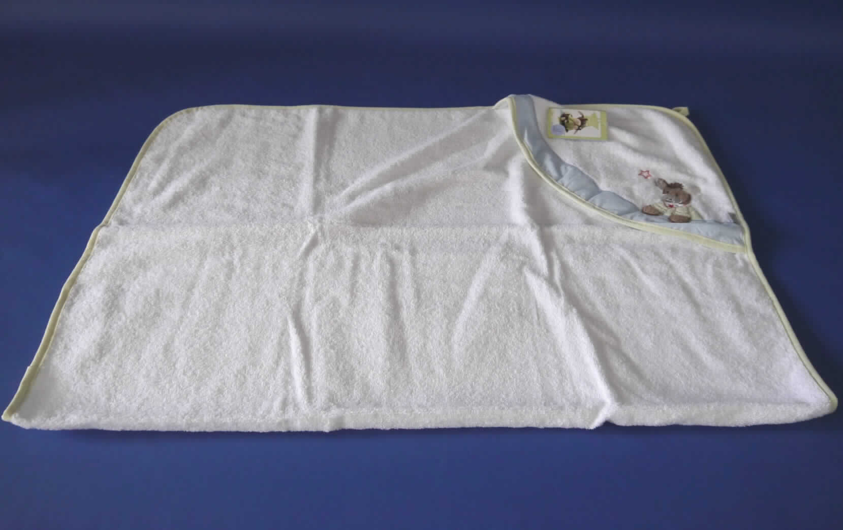 Es handelt sich um ein Set, bestehend aus sieben in einem Karton verpackten Waren: eine Wickelauflage, ein Kapuzenbadentuch, vier Waschlappen, ein Bade-Thermometer, ein Mittelmeerschwamm (Naturschwamm), ein Baby-Kamm und eine Baby-Bürste.  
Die Waren dienen weder der Befriedigung eines speziellen Bedarfs noch der Ausübung einer bestimmten
Tätigkeit und stellen sich somit nicht als Warenzusammenstellung i. S. d. AV 3 b) dar. Sie sind getrennt einzureihen.

Bei dem sog. Kapuzentuch, Art-Nr. 20440 0001BS handelt es sich um ein Badetuch für Babys und Kleinkinder
- aus ca. 3 mm dicken, weißen Schlingengeweben (Frottierware) aus 100 % Baumwolle,
- in den Abmessungen: 80 cm x 80 cm,
- an einer Ecke mit einem aufgenähten, annähernd dreieckigen Zuschnitt aus weißen 
  Schlingengeweben versehen, der einem Kleinkind als Kapuze dient; mit Aufdrucken 
  und einem blauen Streifen aus Geweben aus Spinnstoffen verziert, 
- an den Ecken abgerundet und an den Rändern mit einem hellgrünen Streifen aus 
  Geweben aus Spinnstoffen eingefasst,
- mit einer Aufhängeschlaufe versehen,
- durch Zusammennähen konfektioniert, 
- wird üblicherweise gewaschen,
- in einem bedruckten Karton mit Sichtfenster verpackt.

Die Ware ist als "Wäsche zur Körperpflege, aus Spinnstoffen, aus Frottierware aus Baumwolle, aus Geweben" einzureihen.