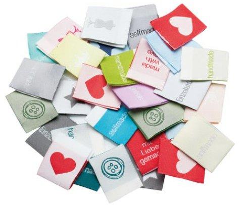 Etikett, sog. handmade-Labels, Foto siehe Anlage,
- 30 Stück in einem Polybeutel verpackt,
- in den Abmessungen von laut Antrag 2,5 cm x 6,4 cm,
- aus einem Jacquardgewebe aus synthetischen Chemiefasern (laut Antrag Polyester),
- mit Kanten, die durch Heißschneiden gegen Ausriefeln gesichert sind und keine deutlichen
  Schmelzkanten aufweisen (= nicht gesäumt / damit nicht weitergehend konfektioniert),
- mit eingewebten Inschriften und Motiven,
- nicht bestickt.

"Etikett, aus Spinnstoffen, zugeschnitten, nicht bestickt, gewebt, mit eingewebten Inschriften oder
 Motiven"