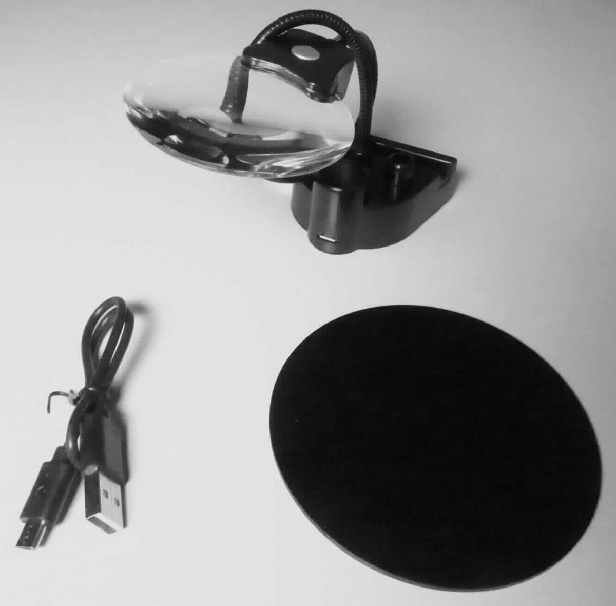 Lupe mit Standfuß, In Form einer noch nicht zusammengesetzten Ware, bestehend aus einem runden, ungefassten Lupenglas mit zwei Vergrößerungen, in einer Halterung mit zwei LEDs (UV-Licht und 3000 K-Licht), die über einen Schwanenhals mit einem magnetischen Standfuß verbunden ist, der auf einer beiliegenden runden Metallplatte fixiert wird. Beigefügt ist außerdem ein USB-Kabel (funktionelle Einheit) zur Stromversorgung.
Alle Bestandteile sind gemeinsam in einem bedruckten Karton verpackt.
Zur äußeren Form siehe Abbildung in Anlage.

Die Ware wird als "optisches Gerät, im Kapitel 90 anderweit weder genannt noch inbegriffen, keine Ware der Unterpositionen (KN) 9013 1000 bis 9013 8020, kein elektronischer Halbleiter-Mikrospiegel" eingereiht.