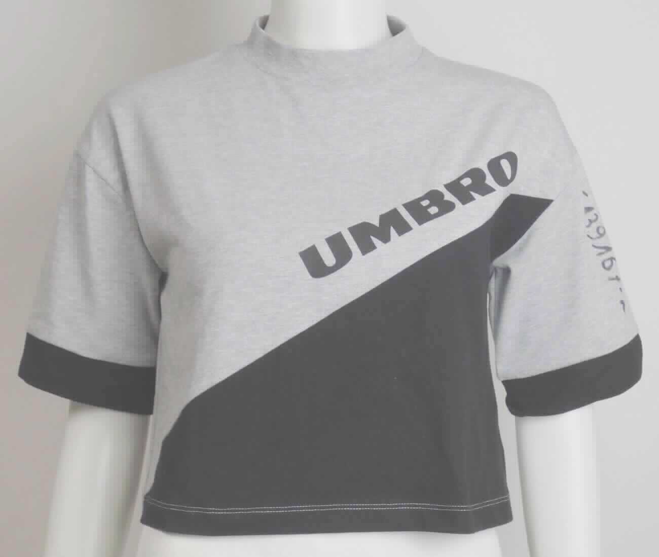 Pulloverähnliches Kleidungsstück, sog. T-Shirt Umbro Temp Crop Tee, Größe S, Foto siehe Anlage,
- aus ca. 0,6 mm dicken, verschiedenen einfarbigen Gewirken aus laut Antrag 95 % Baumwolle und 5 % Elasthan 
  (synthetische Chemiefasern),
- über die Taille reichend (Rückenlänge: ca. 44 cm),
- mit einem angesetzten, hohen Kragen (somit keine Ware der Position 6109),
- ohne Hinweise auf den Trägerkreis (unisex),
- mit kurzen Ärmeln,
- nicht enganliegend gearbeitet (somit kein Unterziehpulli),
- am unteren Rand durch Umschlagen und Festnähen gesäumt.

"Pulloverähnliches Kleidungsstück, aus Gewirken, aus Baumwolle, kein Unterziehpulli, für Frauen"