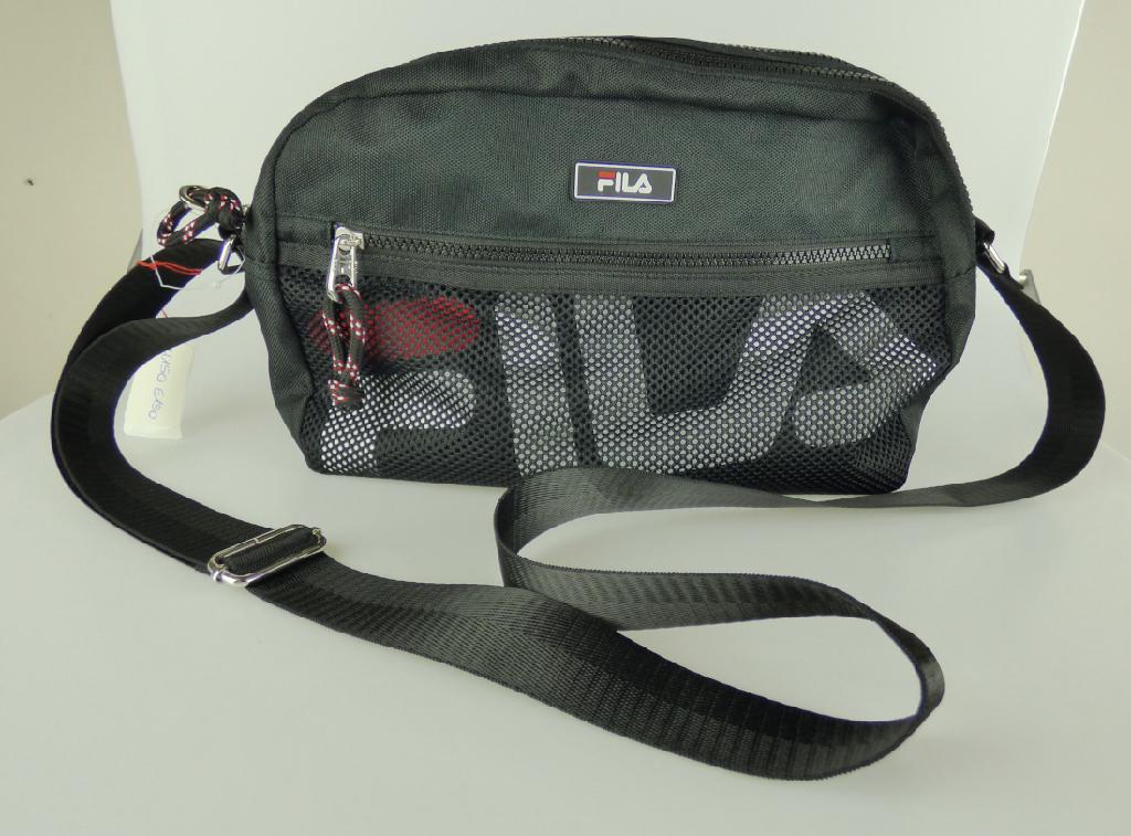 Handtasche, sog. Fila 23948A-50 black, Foto siehe Anlage,
- mit einer Außenseite aus Spinnstoffen,
- mit einem längenverstellbaren Schultertragegurt,
- an der Vorderseite mit einem eingesetzten Einsteckfach mit Reißverschluss und mit einer äußeren Seite
  des Fachs aus Netzstoffen, wodurch das darunterliegende Firmenlogo sichtbar ist,
- an der Rückseite mit einem Einsteckfach mit Magnetknopfverschluss,
- mit zwei Hauptfächern, die jeweils mit einem entlang des oberen Rands bis zu den Seiten verlaufenden
  Reißverschluss zu öffnen sind,
- gefüttert; im hinteren Fach mit einem eingesetzten Reißverschlussfach ausgestattet,
- in den Abmessungen von ca. 31 cm (Breite) x 21 cm (Höhe) x 11 cm (Tiefe),
- laut Antrag nicht handgearbeitet,
- Handtasche, da aufgrund der Form, der Größe und des Gesamteindrucks in erster Linie dazu geeignet,
  kleinere, persönliche Gegenstände aufzunehmen.

"Handtasche, mit Außenseite aus Spinnstoffen, nicht handgearbeitet"