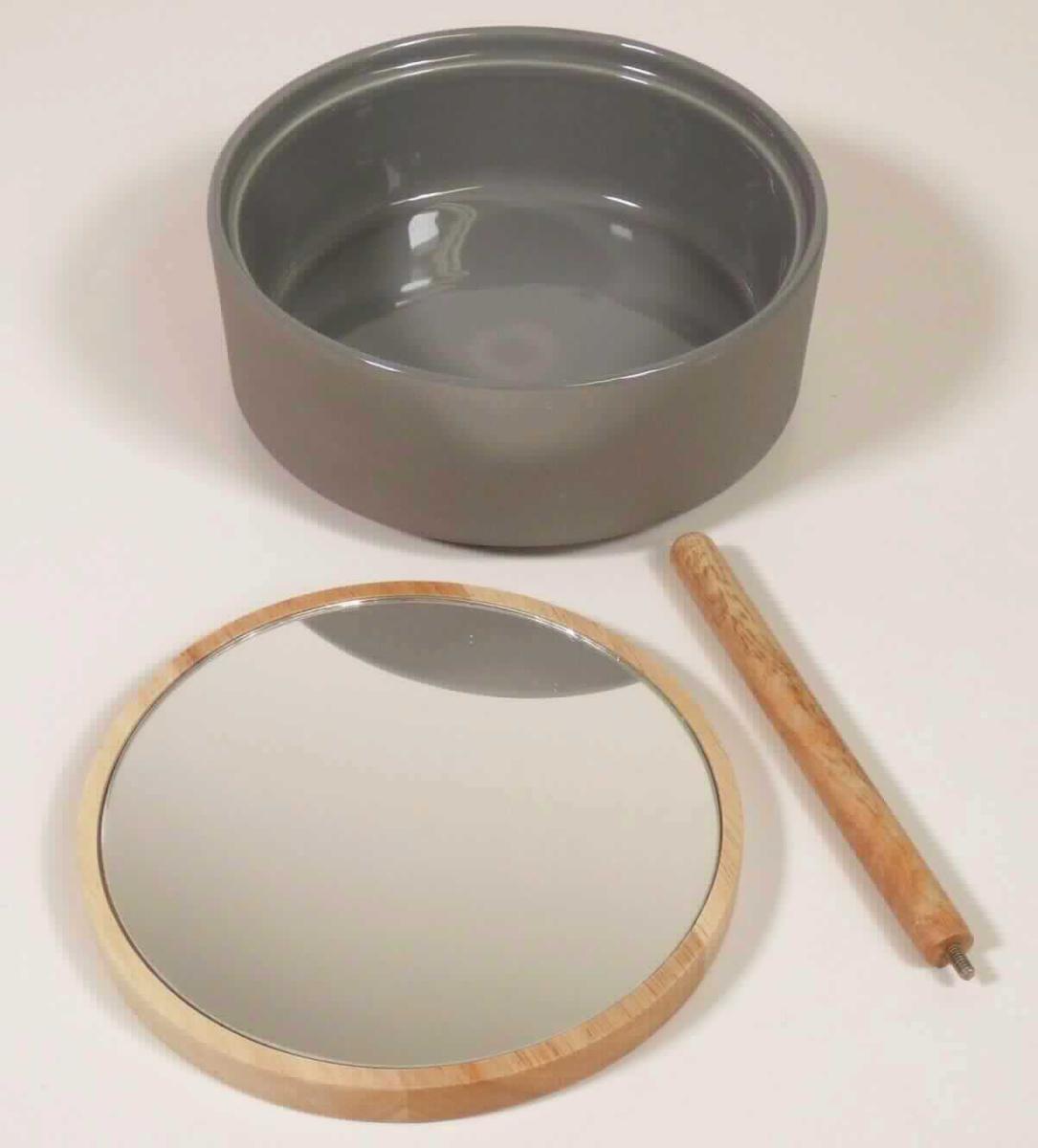 Keramischer Toilettengegenstand, Foto siehe Anlage, 
- zylinderförmige Dose mit Deckel in Form einer zusammengesetzten Ware,
- glasierte, zylinderförmige Dose:
- - mit einem Durchmesser von ca. 16 cm und einer Höhe von ca. 6,5 cm, 
- - keramisches Erzeugnis, nach der Formgebung gebrannt, tonmineralhaltiges Material enthaltend, 
- - lt. Antrag aus Steinzeug,
- runder Deckel:
- - mit einem Durchmesser von ca. 15 cm und einer Dicke von ca. 1 cm, 
- - aus Holz (lt. Antrag vom Gummibaum),
- - auf der Innenseite mit einem eingeklebten Spiegel aus Glas,
- - mit einem mittig auf den Deckel aufschraubbaren, ca. 14 cm langen Holzstab (Griff), mittels dem der Deckel
    (mit dem Spiegel) schräg auf die Dose gestellt oder als Handspiegel verwendet werden kann,
- u. a. aufgrund des in den Deckel eingeklebten Spiegels erkennbar zur Verwendung als Toilettengegenstand
  (z. B. als Wattedose oder zur Aufbewahrung von Kosmetikartikeln) im Badezimmer bestimmt,
- die Dose aus Steinzeug bestimmt nach dem Umfang und ihrer Bedeutung in Bezug auf die Verwendung (dient
  der dauerhaften Aufbewahrung von z. B. Watte oder Kosmetikartikeln) den wesentlichen Charakter der
  zusammengesetzten Ware,
- in einem Karton verpackt.

"Keramischer Toilettengegenstand, aus Steinzeug"