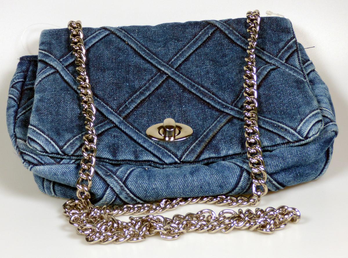 Handtasche, sog. SB 207 Flap-Over-Medium Jeans, Foto siehe Anlage,
- mit einer Außenseite aus Spinnstoffen (Gewebe aus laut Antrag Baumwolle; washed Denim),
- mit einem Schultertrageriemen in Form einer Gliederkette aus unedlem Metall,
- mit einer Überschlagklappe mit einem Drehverschluss,
- mit einem aufgesetzten Vorfach; von der Überschlagklappe verdeckt,
- das Hauptfach ist ebenfalls von der Überschlagklappe verdeckt,
- - gefüttert; ohne Inneneinteilung,
- mit den Abmessungen: ca. 25 cm (Breite) x 19 cm (Höhe) x 5 cm (Tiefe),
- laut Antrag nicht handgearbeitet,
- Handtasche, da aufgrund der Größe und des Gesamteindrucks in erster Linie dazu geeignet,
  kleinere, persönliche Gegenstände aufzunehmen.

"Handtasche, mit Außenseite aus Spinnstoffen, nicht handgearbeitet"