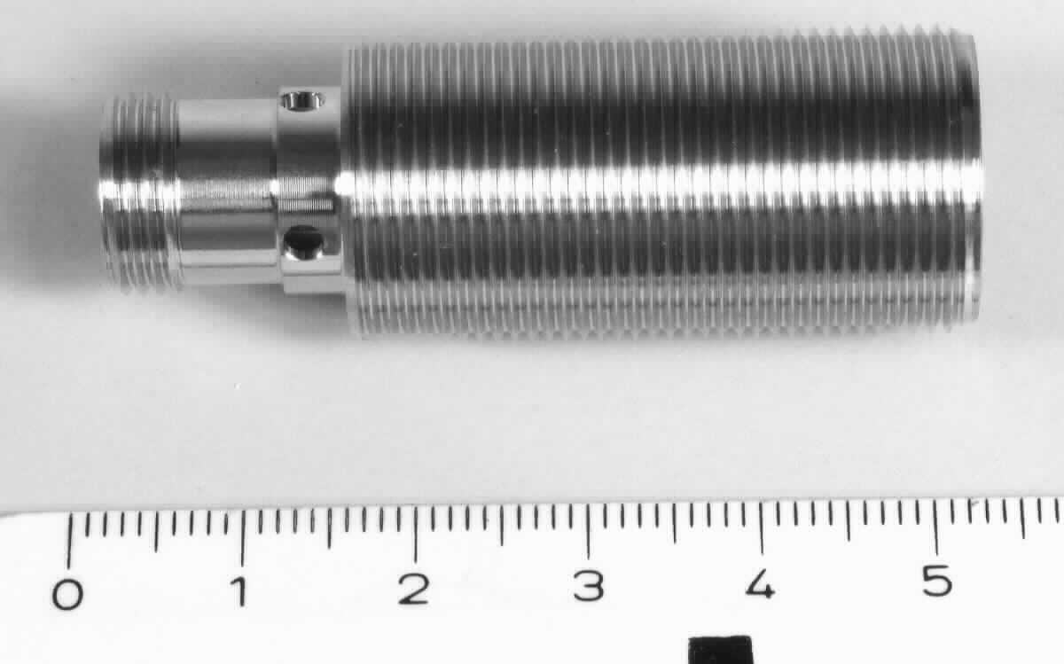 Gehäuse,
- aus einem zweifach abgestuften, zylinderförmigen Hohlerzeugnis (Gesamtlänge: 50 mm) 
  aus Edelstahl (Werkstoffnummer: 1.4404) mit einem Außengewinde (M18, Länge: 36 mm), 
  mit einer zylinderförmigen Spitze (Länge: 14 mm), an der Basis mit vier über Kreuz gesetzten 
  Bohrungen (Durchmesser: 2 mm), an der Spitze mit einem Außengewinde (M12, Länge: 5 mm)
  - Abbildung siehe Anlage -, 
- dient gleichermaßen als Gehäuse für Schalter der Position 8536 und Sensoren der Position 9031.

"Nichtelektrischer Teil von Maschinen, Apparaten und Geräten, in Kapitel 84 anderweit weder genannt noch inbe-
griffen, keine Ware der Codenummern 8487 1010 00 0 bis 8487 9090 10 0 - sog. Gehäuse"