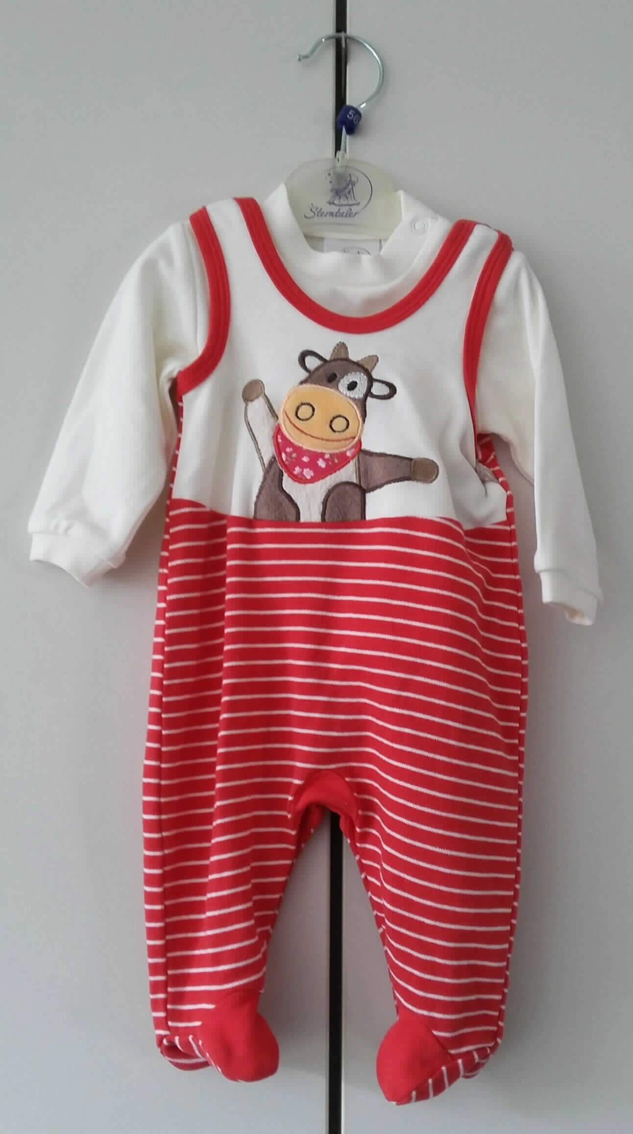 Overall und Bluse, sog. Babystrampler, Art. 2601403, Kleinkindergröße 56, Foto siehe Anlage,
- als zweiteilige Zusammenstellung, bestehend aus einem sog. Strampler und einem sog. Pulli, 
- auf einem einfachen Kleiderbügel aus Kunststoff und Metall hängend, 
- sind für Kleinkinder mit einer Körpergröße von bis zu 86 cm bestimmt,
- Overall (sog. Strampler):
-- aus verschiedenen, bis zu ca. 1 mm dicken, einfarbigen bzw. buntgewirkten Gewirken aus laut Antrag 
   100 % Baumwolle,
-- einteilig, den gesamten Körper mit Ausnahme von Kopf, Hals und Armen bedeckend,
-- mit einem runden Halsausschnitt,
-- ärmellos; an den Schultern mit Öffnungen mit Druckknopfverschluss,
-- an den Rändern des Halsausschnitts und der Armausschnitte mit Gewirkestreifen eingefasst,
-- im Brustbereich mit einer Applikation verziert,
-- entlang der Beininnenseiten und des Schrittbereichs mit einer Öffnung mit Druckknopfverschluss,
- Bluse (sog. Pulli):
-- aus ca. 0,8 mm dicken, einfarbigen Gewirken aus laut Antrag 100 % Baumwolle,
-- über die Taille reichend,
-- mit einem runden Halsausschnitt,
-- im Bereich der linken Schulter mit einer vom Halsausschnitt ausgehenden, kurzen Öffnung mit Druckknopf-
   verschluss,
-- mit langen Ärmeln, mit angesetzten, verengenden Bündchen,
-- am unteren Rand durch Umschlagen und Festnähen gesäumt.

"Kleidung (Overall und Bluse), für Kleinkinder, aus Gewirken, aus Baumwolle"