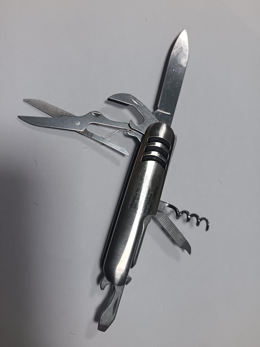"Taschenmesser"

aus verschiedenen Bestandteilen zusammengesetzte Ware, bestehend aus

- einem Klappmesser (Taschenmesser; charakterbestimmend) mit schneidender Klinge aus Stahl und
  Griffschalen aus unedlem Metall, in die gemeinsam unlösbar eine Schere, ein Dosenöffner, ein
  Korkenzieher, eine Feile, ein Kreuzschlitzschraubendreher sowie ein Flaschenöffner (jeweils aus
  unedlem Metall) eingesetzt sind; die Griffschalen sind beidseitig, senkrecht zur Längsachse mit
  sichelähnlichen, erhabenen Gummistreifen versehen

- einem an den Griffschalen angebrachten Schlüsselring aus unedlem Metall mit angehängtem
  Warenetikett (Ware mit geringem Wert)

- gemeinsam in einem speziell zur Aufnahme der o. g. Erzeugnisse gestalteten und zum dauernden
  Gebrauch geeigneten  Etui aus Kunststoff mit Gürtelschlaufe und einem bedruckten Pappkarton
  aufgemacht

Abbildung siehe Anlage.

Derartige Erzeugnisse gehören als "Messer mit schneidender, nicht feststehender Klinge aus unedlem
Metall, kein Messer der Pos. 8208" zum TARIC-Code 8211 9300 00.