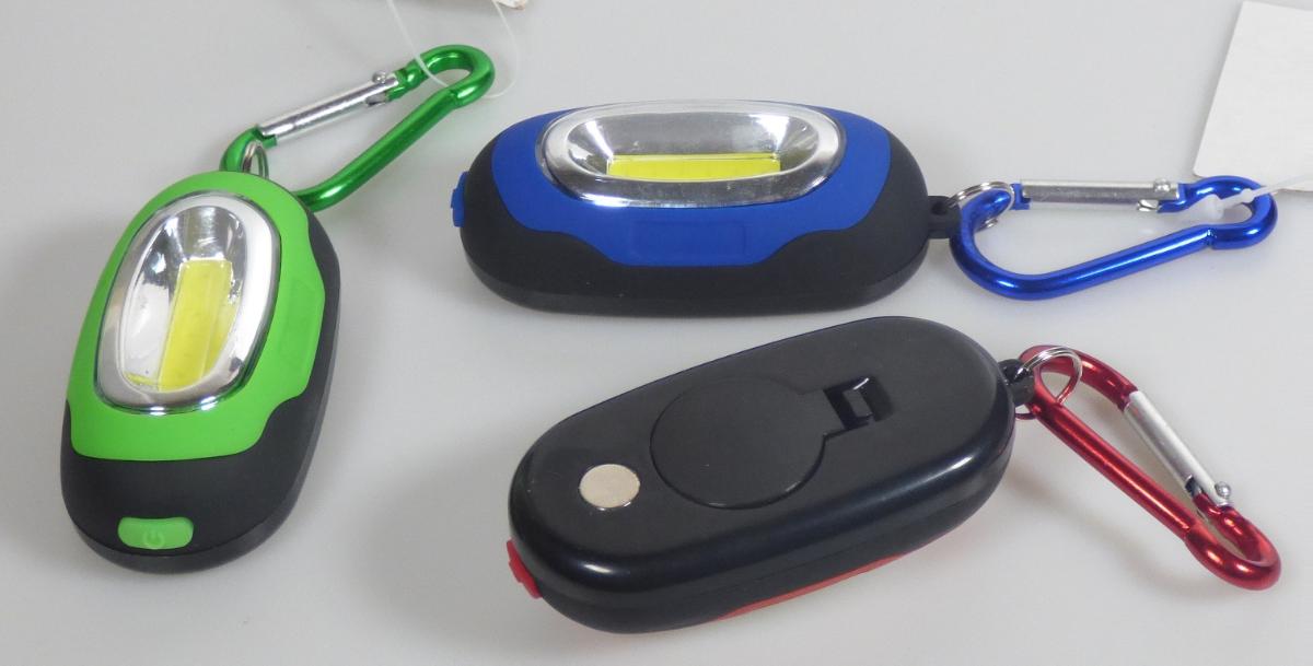 "Kompakt-Licht im 24er-Display, mit Karabinerhaken und Magnet, Artikel 36142"
(Abbildung siehe Anlage)

- aus einem COB-LED-Array (Dauerlicht in zwei Helligkeitsstufen oder Blinklicht aussendend),
  eingebaut in einem Kunststoffgehäuse mit Ein-/ Ausschalter, Magnethalterung, Batteriefach mit
  zwei eingelegten Batterien und an einem Karabinerhaken aus unedlem Metall befestigt,
  Abmessungen 70 x 30 x 24 mm,
- zur Verwendung als tragbare elektrische Leuchte (Dauerlicht) -kennzeichnende Haupttätigkeit- und 
  Sichtsignalgerät (Blinklicht),
- zusammen mit 23 weiteren, baugleichen Taschenlampen in einem Verkaufsdisplay
  aus Karton aufgemacht.

"Tragbare elektrische Leuchte zum Betrieb mit eigener Stromquelle, kein Beleuchtungsgerät
 der Position 8512 (Multifunktionsgerät aus tragbarer elektrischer Leuchte - kennzeichnende
 Haupttätigkeit - und Sichtsignalgerät) - sog. Kompakt-Licht"