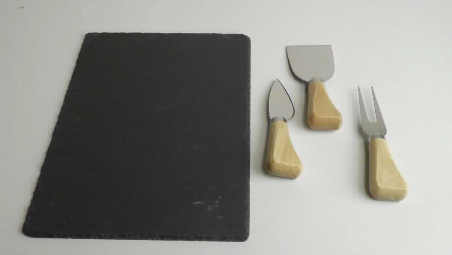 Angaben:
Käse-Servier-Set, 4-tlg, Schiefer, Edelstahl 420, Kautschuk Holz.

Warenbeschaffenheit:
Quaderförmige Schieferplatte (Abmessungen ca. 24 x 18 cm) mit gefasten Kanten und abgerundeten Ecken, ein Käsemesser mit Klinge aus unedlem Metall, ein Käsespalter mit arbeitendem Teil aus unedlem Metall und eine Käsegabel mit zwei Zinken aus unedlem Metall, gemeinsam verpackt in Kartonumverpackung.

Befund:
Ware aus Tonschiefer oder aus Pressschiefer

Warenzusammenstellung, bei der im Hinblick auf den Wert und den Umfang das Schieferbrett als charakterbestimmend angesehen wird.
