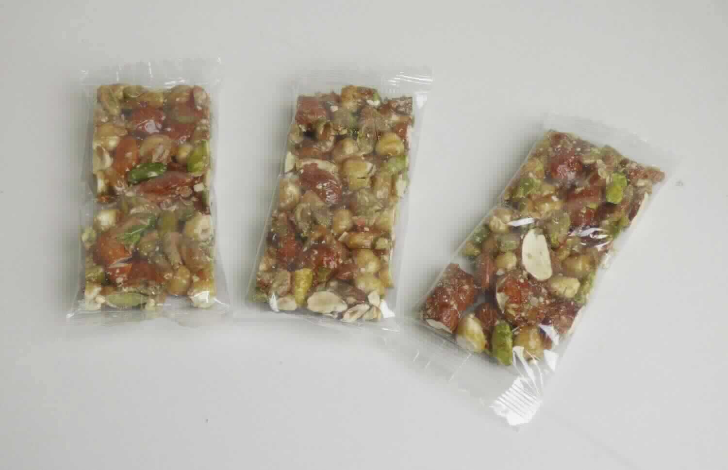 Nussriegel

Antragsangaben (als zutreffend unterstellt): Nuss Mix Riegel, 40 g. Zutaten: Pistazien 21,5 %, Mandeln 21,5 %, Haselnuss 21,5 %, Zucker 22 %, Glukosesirup 13,5 %. Herstellung: 1) Nüsse werden vermischt, 2) Zucker und Glucosesirup werden durch Erhitzen karamellisiert, 3) Nüsse werden in die Karamellmasse eingefügt und zu einer Masse vermischt, 4) Masse wird geformt, in Riegelform zugeschnitten und anschließend gekühlt.

Beschaffenheit der vorgelegten Warenprobe: ca. 10,5 x 4,5 x 1,3 cm großer Riegel aus Mandeln, Pistazien und Haselnüssen als ganze Nüsse und als Stückchen, die mit einer dünnen Karamellschicht teilweise überzogen und untereinander verklebt sind. Geschmack: nussig, süß, Röstaroma erkennbar. Aufmachung: Schlauchfolie, Nettogewicht: ca. 40 g.

Früchte, Nüsse und andere genießbare Pflanzenteile, in anderer Weise zubereitet oder haltbar gemacht, auch mit Zusatz von Zucker, anderen Süßmitteln oder Alkohol, anderweit weder genannt noch inbegriffen, Schalenfrüchte, Erdnüsse und andere Samen, auch miteinander vermischt, andere, einschließlich Mischungen, in unmittelbaren Umschließungen mit einem Gewicht des Inhalts von 1 kg oder weniger, andere, geröstete Nüsse, andere, andere.