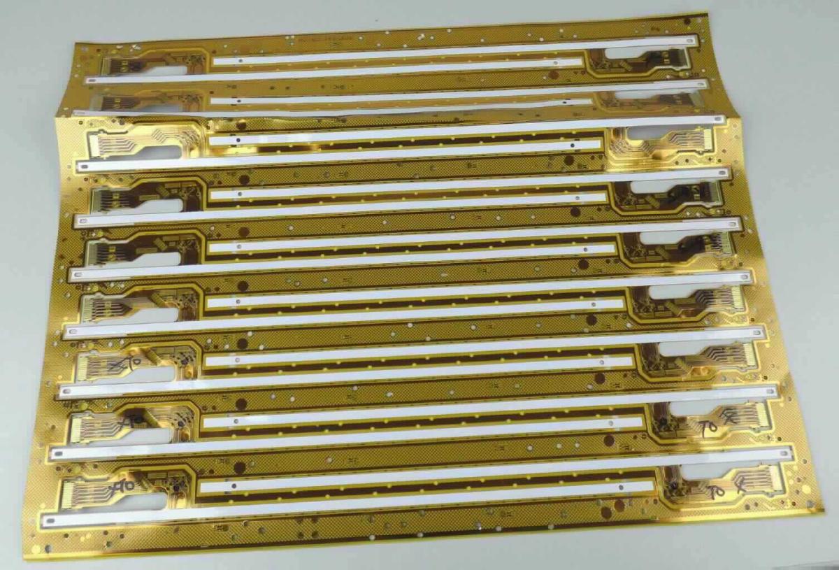 Unfertige Flexible Leiterplatte (Abbildung siehe Anlage)
- in Form einer einlagigen gedruckten Schaltung mit im Druckverfahren 
  aufgebrachten Leiterbahnen und Kontakten, an den Enden mit Verstärkungen
  sowie einseitig mit einer Selbstklebeschicht versehen,
- neun davon auf einem gemeinsamen Nutzen, noch nicht vereinzelt.

"Gedruckte Schaltung, nur mit Leiterbahnen oder Kontakten, keine Mehrlagenschaltung, unfertig"