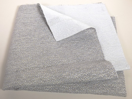 Textillaminat, sog. Möbelbezugsstoff, Art. Chester, Foto siehe Anlage,
- als Meterware, mit einer Breite von laut Antrag 145 cm,
- aus zwei mit ihrer ganzen Fläche aufeinanderliegenden und so miteinander durch Kleben 
  verbundenen Lagen:
-- mit einer Oberlage (Schauseite):
--- aus einem Chenillegewebe; mit samtartiger Oberfläche,
--- aus Chenillegarnen und anderen Garnen; beide aus synthtischen Chemiefasern (laut 
    Antrag Polyester),
-- mit einer Unterlage:
--- aus einem einfarbigen Gewebe aus synthetischen Chemiefasern,
- das die Schauseite bildende Chenillegewebe verleiht der Ware insbesondere im Hinblick
  auf die Verwendung als Möbelbezugsstoff ihren wesentlichen Charakter.

"Chenillegewebe, keine Ware der Positionen 5802 oder 5806, aus Chemiefasern"