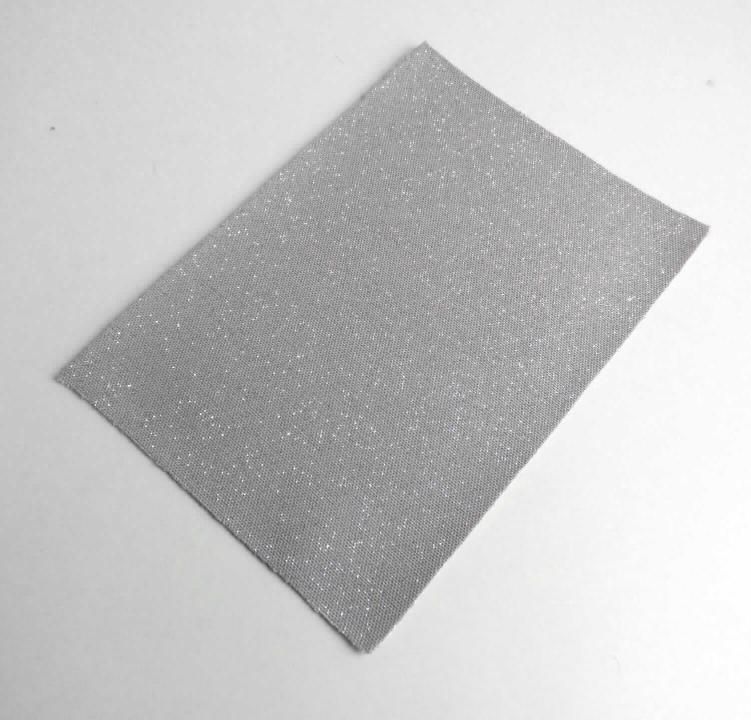 Textillaminat, sog. Material zur Schuhherstellung, Foto siehe Anlage,
- als Meterware, mit einer Breite von laut Antrag 130 cm,
- laut Untersuchungsergebnis:
-- aus drei mit ihrer ganzen Fläche aufeinander liegenden und so miteinander durch Kleben verbundenen Lagen:
--- mit einer Oberlage (Schauseite):
---- aus einem Kettengewirke,
---- aus synthetischen Chemiefasern (laut Antrag 80 % Polyester und 8 % Elastomergarne),
---- keine Kautschukfäden enthaltend,
---- musterbildend mit Kunststoff-Partikeln bedruckt,
--- mit einer Zwischenlage:
---- aus einem gefärbten Gewirke,
---- aus synthetischen Chemiefasern und Elastomergarnen,
--- mit einer Unterlage:
---- aus einem einfarbigen Gewebe aus synthetischen Chemiefasern,
- insbesondere im Hinblick auf die Verwendung verleiht das die Schauseite bildende Kettengewirke der Ware ihren  
  wesentlichen Charakter.

"Gewirke, mit einer Breite von mehr als 30 cm und mit einem Anteil an Elastomergarnen von mehr als 5 GHT, 
 andere als solche der Position 6001, keine Kautschukfäden enthaltend, aus synthetischen Chemiefasern"