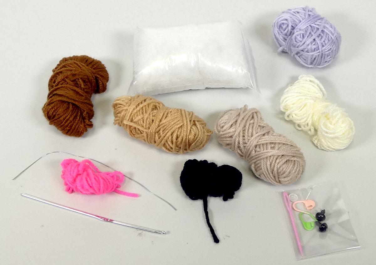 Häkel-Set, Foto siehe Anlage,
- Warenzusammenstellung, bestehend aus sieben Garnen, einer Häkelnadel, einer Wollnadel,
  Füllmaterial, zwei Maschenmarkierer, einem Basteldraht, zwei "Kunststoffaugen" und laut
  Antrag einer Anleitung,
- laut Antrag gemeinsam in einer bedruckten Pappschachtel für den Einzelverkauf aufgemacht 
  und zur Befriedigung eines speziellen Bedarfs zusammengestellt,
- Garne:
-- aus synthetischen Spinnfasern (laut Antrag Polyacryl),
-- gezwirnt, mit einer S-Drehung als letzter Drehung,
-- im Knäuel (ohne Unterlage, u. a. deshalb kein Nähgarn),
-- mit einem Gewicht von nicht mehr als 500 g (Garn in Aufmachungen für den Einzelverkauf), 
-- mit einem Titer von unter 10.000 dtex, somit kein Bindfaden,
- Häkelnadel:
-- mit einer Länge von ca. 15 cm,
-- aus unedlem Metall, 
- Wollnadel:
-- mit einer Länge von ca. 7 cm,
-- aus Kunststoff,
- Füllmaterial:
-- aus losen synthetischen Spinnfasern,
- Maschenmarkierer:
-- aus Kunststoff,
- Basteldraht:
-- mit einer Länge von ca. 20 cm,
-- aus unedlem Metall,
- sog. Kunststoffaugen:
-- aus Kunststoff,
-- auf der Unterseite mit Stiften, auf die Kunststoffscheiben gesteckt werden,
- Anleitung:
-- aus Papier,
-- laut Antrag bedruckt mit einer Häkelanleitung,
- erfüllt als Handarbeitsset nicht die Bedingungen zur Einreihung in die Position 9503,
- die Garne bestimmen insbesondere im Hinblick auf die Bedeutung in Bezug auf die Verwendung
  den Charakter der Warenzusammenstellung.

"Garne aus synthetischen Spinnfasern, kein Nähgarn, in Aufmachungen für den Einzelverkauf, mit
 einem Anteil an synthetischen Spinnfasern von mehr als 85 GHT"
