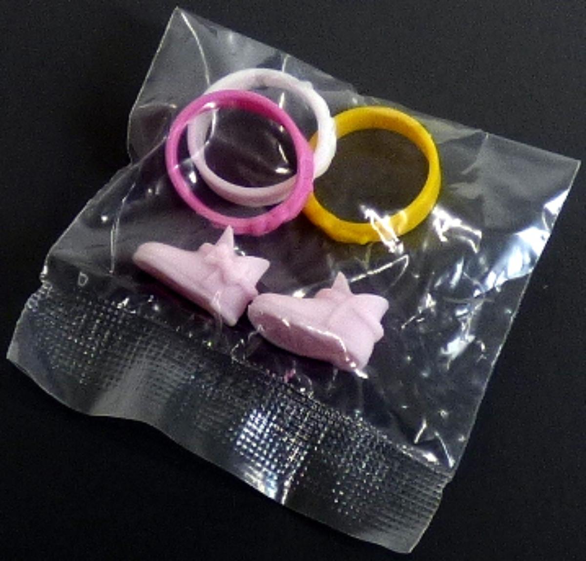 Es handelt sich um Puppenzubehör in Form von Bekleidungszubehör (Artikelnummer 40700820),
- die Nachbildung von einem Paar Schuhe aus Kunststoff bzw. Kautschuk,
- mit einer Länge von ca. 1,9 cm,
- erkennbar hauptsächlich für kleine Puppen bestimmt,
- dient der spielerischen Unterhaltung von Kindern.

Die Schuhe sind gemeinsam mit drei Fingerringen (DEBTI-39496/20-2) in einem bedruckten Polybeutel als Verkaufseinheit verpackt.
Es handelt sich nicht um eine Warenzusammenstellung im Sinne der AV 3 b), da die Waren weder zur Befriedigung eines speziellen Bedarfes noch zur Ausübung einer bestimmten Tätigkeit zusammengestellt wurden. Sie sind daher getrennt einzureihen.

Die Ware ist zolltarifrechtlich als "Zubehör, erkennbar hauptsächlich für Puppen, nur Nachbildungen von Menschen darstellend" einzureihen.