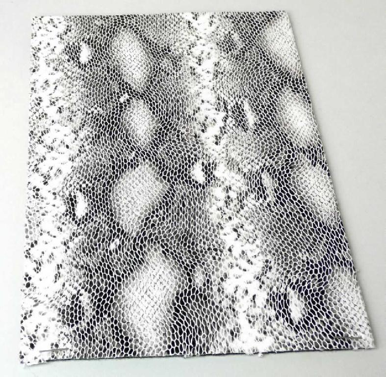 Gewebe mit Kunststofflage, sog. Material zur Schuhherstellung, Foto siehe Anlage,
- als Meterware, mit einer Breite von laut Antrag 140 cm,
- laut Untersuchungsergebnis:
-- dreilagig gearbeitet,
--- mit einer Außenlage aus einem musterbildend mit Kunststoff bedruckten Kuliergewirke der Position 6006
     aus synthetischen Chemiefasern,
--- mit einer Zwischenlage aus Zellkunststoff (laut Antrag Polyester), 
--- mit einer Innenlage aus einem Kuliergewirke (= Gewebe im Sinne des Kapitels 59) aus synthetischen
     Chemiefasern,
- von Hand bei einer Temperatur zwischen 15 und 30 °C auf einen Dorn von 7 mm Durchmesser aufrollbar, 
  ohne rissig zu werden.

"Gewebe, mit Kunststoff (Polyester) laminiert, anderes als solches der Position 5902, mit Schauseite aus 
 Spinnstoffen"