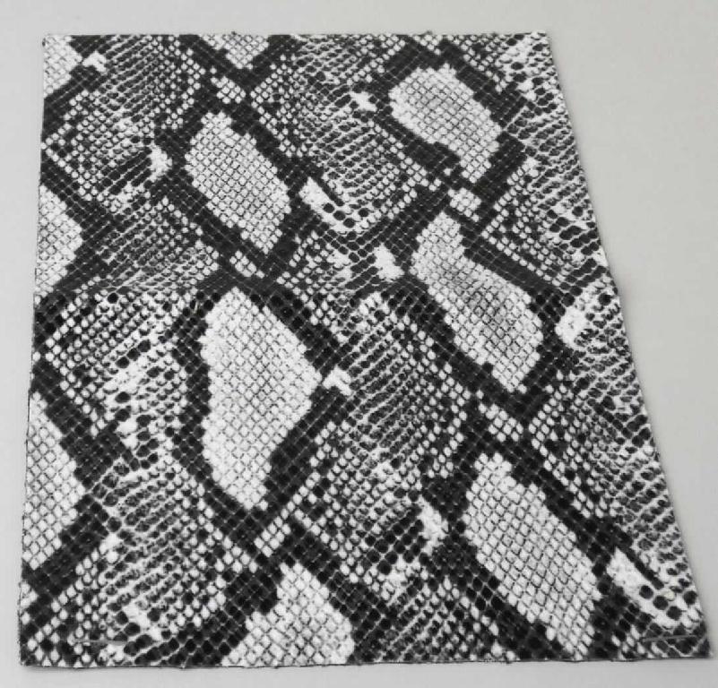 Textillaminat, sog. Material zur Schuhherstellung, Foto siehe Anlage,
- als Meterware, mit einer Breite von laut Antrag 140 cm,
- laut Untersuchungsergebnis:
-- aus zwei mit ihrer ganzen Fläche aufeinander liegenden und so miteinander durch Kleben verbundenen Lagen: 
--- mit einer Oberlage (Schauseite): 
---- aus einem gerauten Kettengewirke aus synthetischen Chemiefasern, 
---- musterbildend mit Farbe und Kunststoff bedruckt,
---- ohne Flor- oder Schlingenoberfläche,
---- keine Elastomergarne oder Kautschukfäden enthaltend,
--- mit einer Unterlage:
--- aus einem Kuliergewirke aus synthetischen Chemiefasern,
- insbesondere im Hinblick auf die Verwendung verleiht das die Schauseite bildende Kettengewirke der Ware ihren
  wesentlichen Charakter.

"Kettengewirke, anderes als solche der Positionen 6001 bis 6004, aus synthetischen Chemiefasern, anderes als 
 in der Unterposition 6005 35 genannte, bedruckt"
