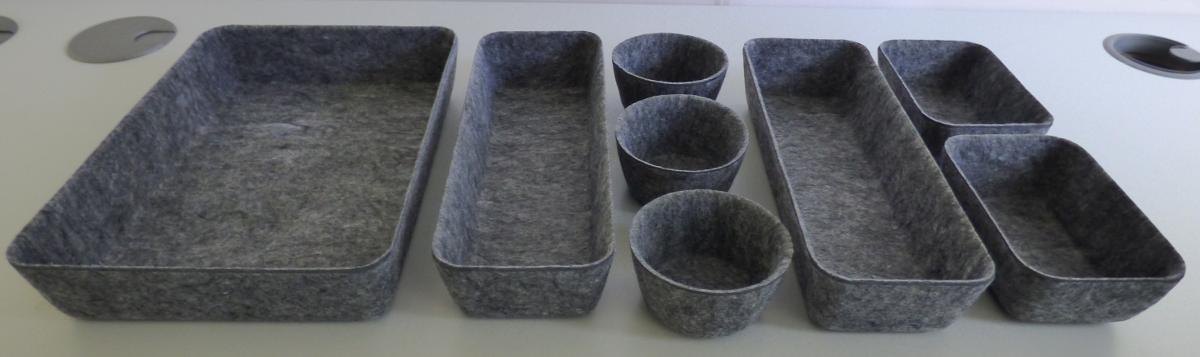Aufbewahrungskörbe, sog. Filz Organizer, Kopf Nan 9991163, 9990864, Foto siehe Anlage,
- als 8-teiliges Set,
- dreidimensional gearbeitet, in unterschiedlichen Formen (rechteckig und rund) laut Antrag mit
  den Abmessungen von Ø 8,8 cm x 5 cm x 5 cm (3x), 13 cm x 9 cm x 5 cm (2x), 27 cm x 10 cm
  x 5 cm (2x) und 27,5 cm x 20 cm x 5 cm (1x),
- laut Untersuchungsergebnis aus genadelten und mit Bindemittel bzw. Bindefasern verfestigten
  Vliesstoffen aus synthetischen Chemiefasern, somit keine Ware aus Filz,
- anders als quadratisch oder rechteckig zugeschnitten, damit konfektioniert,
- stellen sich nicht als Behältnisse der Position 4202 dar, da die Waren weder namentlich im
  Positionswortlaut genannt, noch einem der dort genannten Behältnisse ähnlich sind,
- ohne raumbezogene Funktion, somit keine Waren der Position 6304.

"Andere konfektionierte Waren (Aufbewahrungskörbe), aus Spinnstoffen, aus Vliesstoffen"