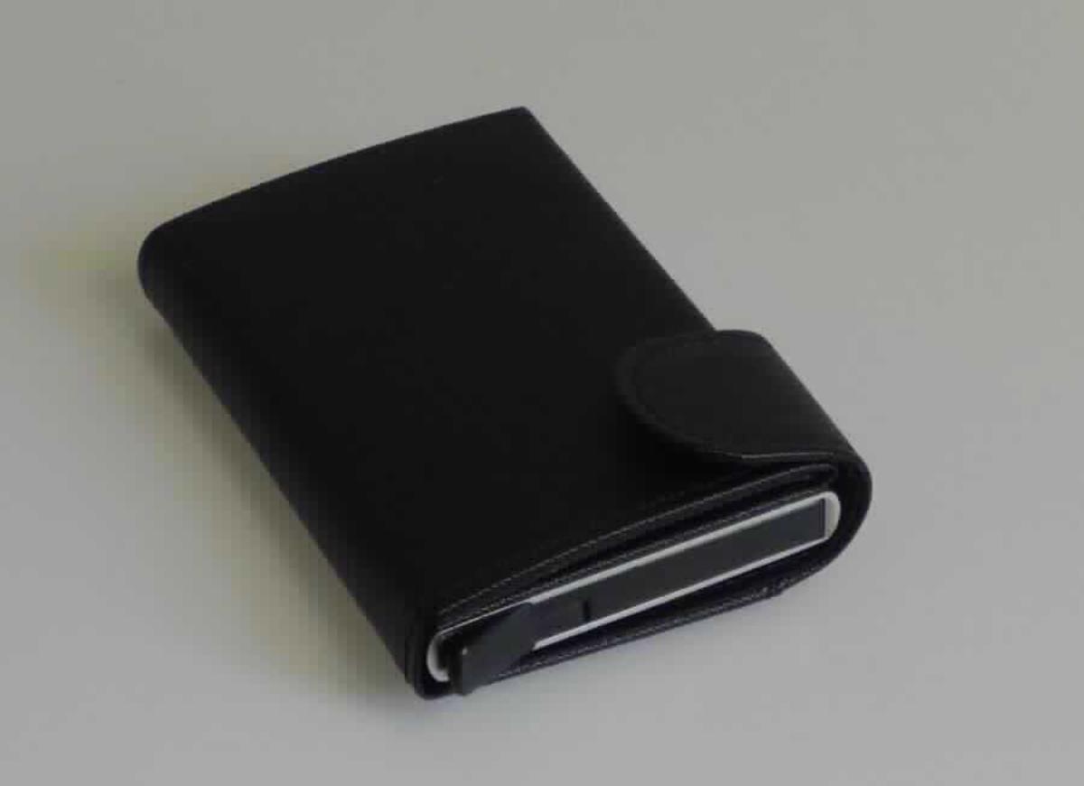 Ähnliches Behältnis (Kreditkartenetui), Taschen- oder Handtaschenartikel, sog. Geldbörse aus Kunstleder (Art. 90669), Foto siehe Anlage,
- mit einer als Umschlag gearbeiteten, flächenmäßig überwiegenden (charakterbestimmenden) Außenseite aus 
  geprägten Kunststofffolien; vorn mit einem Verschlussriegel mit Druckknopf, hinten mit einem offenen
  Einsteckfach,
- ansonsten mit einem Korpus aus unedlem Metall (laut Antrag Aluminium) und aus formgepresstem Kunststoff,
- auf der Innenseite des Umschlags mit einem Scheinfach und einem darin eingesetzten, offenen Einsteckfach,
- mit einem oben offenen, passgenau zum Einstecken von sechs Kreditkarten gearbeiteten Korpus; auf 
  der Unterseite mit einem Ausgabemechanismus zum Auswurf der Kreditkarten,
- laut Antrag mit RFID-Ausleseschutz,
- in den Abmessungen: ca. 9,5 cm (Höhe) x 6,5 cm (Breite) x 1,5 cm (Tiefe).

"Ähnliches Behältnis (Kreditkartenetui), Taschen- oder Handtaschenartikel, mit Außenseite aus Kunststofffolien"