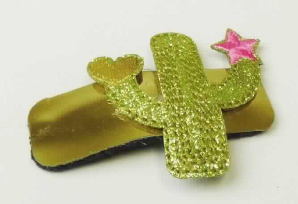Bei dem sog. "Clip Kaktus, LAN 11591" handelt es sich um eine aus verschiedenen Stoffen zusammengesetzte Ware in Form eines Haarclips (Haarspange). Die Ware besteht aus einer auf Spannung gebogenen Metallspange und einer angeklebten, goldfarbenen, ca. 5,6 x 2 cm großen Kunststofffolie mit einem aufgeklebten Kaktus aus Spinn- bzw. Vliesstoff. 
Der obere Teil der Metallspange ist durch eine unter der Kunststofffolie befindlichen Lage aus Vliesstoff verdeckt.

Der stoffliche Charakter wird durch das Metall aufgrund seiner Bedeutung für die Verwendung bestimmt. 

Das Erzeugnis dient dem Zusammenhalten des Haares und ist auf einem Pappaufhänger aufgemacht. 

Die Ware ist als "Haarspangen aus unedlem Metall" einzureihen.