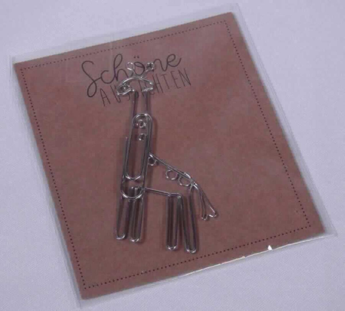 Es handelt sich um Briefklammern aus Draht aus unedlem Metall. Die Erzeugnisse weisen die Form eines Tieres (hier: Giraffe) auf. Sie sind einzeln auf einer bedruckten Pappunterlage befestigt und in einem Folienbeutel verpackt.
-Antragstellerangaben-

Derartige Erzeugnisse gehören als "Briefklammern aus unedlen Metallen" zum TARIC-Code 8305 9000 00.

Abbildung siehe Anlage.