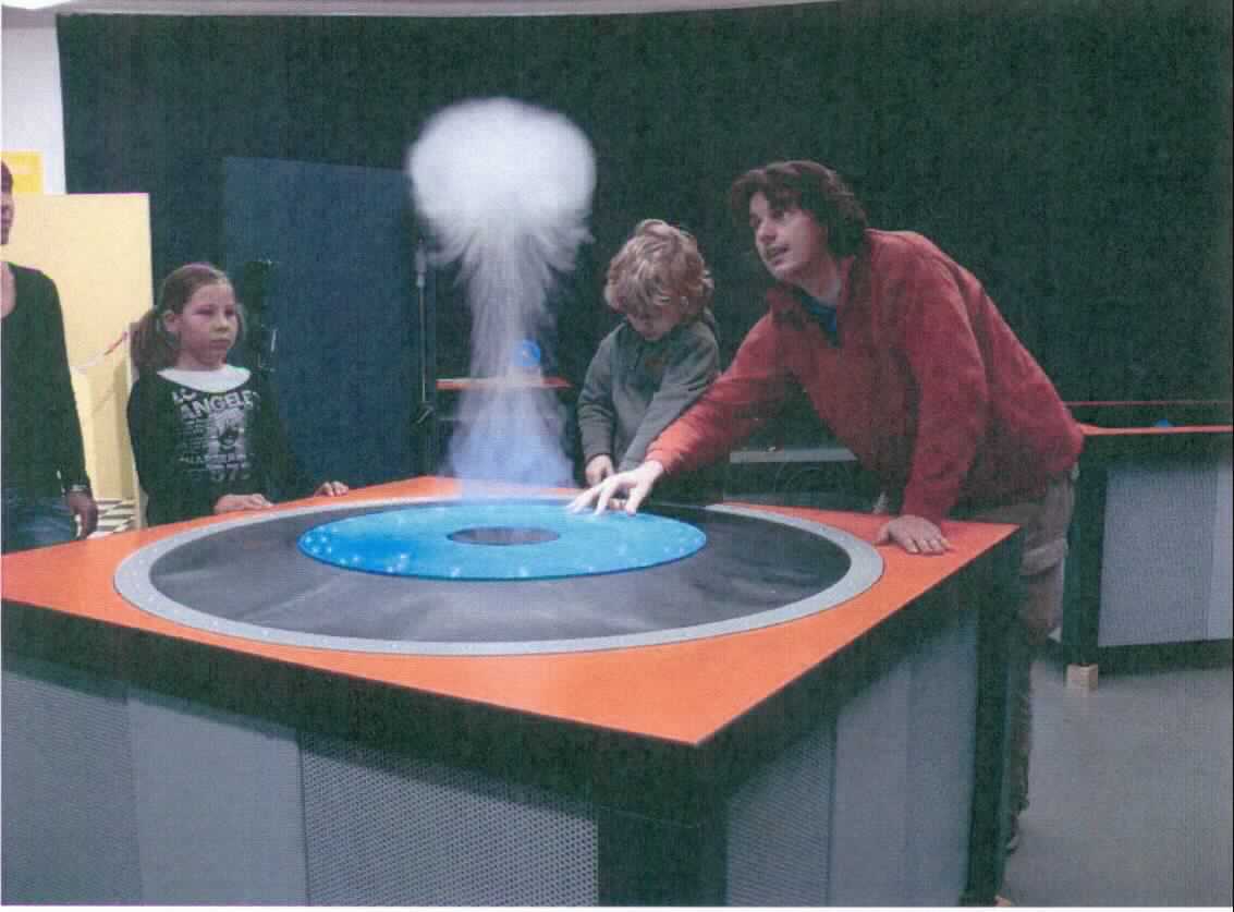 Bei dem Erzeugnis mit der Bezeichnung "Cloud rings" handelt es sich seiner Beschaffenheit und der vorgesehenen Verwendung nach um ein Exponat zu Vorführzwecken in Museen, Science Centern und ähnlichen Einrichtungen, das zur ausschließlichen Wissensvermittlung eines wissenschaftlichen Phänomens dient.

Das Exponat "Cloud rings", Seriennr.: 9636, zeigt experimentell die Entstehung von Wirbelringen und deren Sichtbarmachung mittels Schwebeteilchen. 

Der Besucher kann eine runde Metallstange nach unten drücken, worauf aus einem Loch Nebel aufsteigt. Dieser stellt sich zuerst als pilzförmige Wolke dar und nimmt dann die Form eines aufsteigenden, sich von innen nach außen drehenden Ringes an.

Das ca. 193 kg schwere Erzeugnis ist zur Interaktion durch den Betrachter / Besucher vorgesehen. 

Hauptbestandteile des Exponats (teilweise noch nicht zusammengesetzt):
- rundes Stahlbecken mit einem Durchmesser von 1520 mm,
- unterer, runder Tisch aus Holz,
- Neopren-Membran-Oberfläche mit einem Loch in der Mitte und
- Druckring.

Die Ware ist als "Instrument, Apparat, Gerät und Modell, seiner Beschaffenheit nach zu Vorführzwecken bestimmt, nicht zu anderer Verwendung geeignet, nicht von dem TARIC-Code 9023 0010 00 erfasst" einzureihen.

Anlage: 1 Abbildung