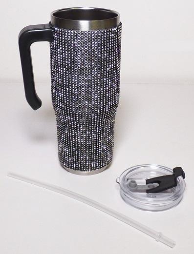 Bei dem sog. "Trinkbecher aus Edelstahl" handelt es sich um eine Warenzusammenstellung in Aufmachung für den Einzelverkauf, im Wesenlichen bestehend aus einem doppelwandigen, ca. 23,0 cm hohen Trinkbecher aus unedlem Metall mit isolierendem Vakuum zwischen den Metallwänden und einem Durchmesser von etwa 9,0 cm  (Nennvolumen: 980 ml) sowie einem Strohalm aus Kunststoff. Der Becher verfügt über einen Henkel sowie einen transparenten Deckel aus Kunststoff mit einer Silikondichtung und Stopfen. Außen ist er mit diamantähnlichen Kunststoffsteinen ummantelt, welche in einem netzartigen Gewebe aus unedlem Metall eingefasst sind.

Der Charakter der Warenzusammenstellung wird im Hinblick auf die Bedeutung in Bezug auf die Verwendung sowie den Umfang durch den Trinkbecher bestimmt. Der Becher dient zum Bereithalten, Kühlen sowie Warmhalten von Getränken.

Die Waren sind gemeinsam in einem dekorativen Karton mit Sichtfenster aufgemacht und als "Vakuum-Isolierbehälter" einzureihen.