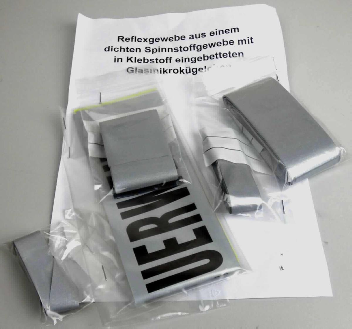 Überzogenes Gewebe, sog. Reflexgewebe, Foto siehe Anlage, 
- als Meterware; veranschaulicht durch unterschiedliche Warenmuster (teilweise mit einem Schriftzug bedruckt), 
- mit Breiten von ca. 2 cm, 2,5 cm, 5 cm und 8 cm, 
- jeweils:
-- aus einem Gewebe aus Spinnstoffen, 
-- mit einer reflektierenden Schicht; bestrichen mit Klebstoff und flächendeckend überdeckt mit nicht vollständig
   eingebetteten, metalisierten Mikro-Glaskugeln (mit einem Durchmesser von weniger als 150 µm), 
-- das Überziehen ist mit dem bloßen Auge wahrnehmbar.

"Überzogenes Gewebe, anderes als in den Positionen 5901 bis 5906 genannte, beschichtet mit in Klebstoff 
 eingebetteten Kügelchen mit einem Durchmesser von nicht mehr als 150 µm"