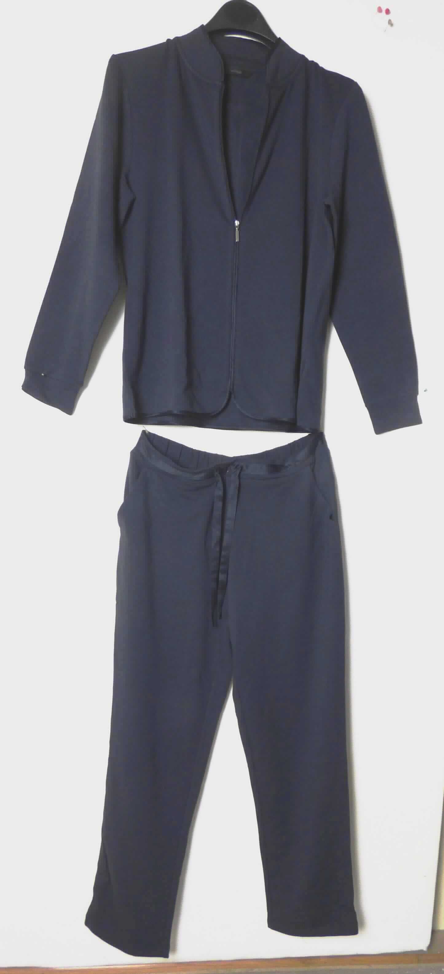 Hemdbluse und lange Hose, sog. Damen Hausanzug, 2tlg., Größe 40/42, Art. P. 98277, Foto siehe Anlage,
- als zweiteilige Zusammenstellung gemeinsam in einem Polybeutel für den Einzelverkauf verpackt,
- aus ca. 0,8 mm dicken, einfarbigen, einseitig (Innenseite) gerauten Gewirken aus laut Antrag 50 % Baumwolle, 
  45 % Modal (künstliche Chemiefasern) und 5 % Elasthan (synthetische Chemiefasern),  
- ohne Hinweise auf den Trägerkreis (unisex),
- keine Kombination im Sinne der Anmerkung 3 b) zu Kap 61, weil die Kleidungsstücke nicht aus ein und demselben 
  Flächenerzeugnis hergestellt sind,
- kein Trainingsanzug, da die Kleidungsstücke nach ihrem allgemeinen Aussehen und ihrer stofflichen 
  Beschaffenheit nicht erkennen lassen, dass sie dazu bestimmt sind, ausschließlich oder im Wesentlichen bei der 
  Ausübung eines Sports getragen zu werden, 
- getrennte Einreihung aller Bestandteile, weil die Kleidungsstücke nicht zusammen in eine Position eingereiht
  werden können,
- Hose:
-- in der Taille abschließend; mit einem ca. 4,5 cm breiten Bund, hinten elastisch verengt, vorn mit durch 
   Tunnelzüge gezogenen Bindebändern aus leicht glänzenden Geweben zu verengen,
-- ohne Öffnung und ohne Verschluss, 
-- ohne Hinweise auf den Trägerkreis (unisex),
-- vorn mit zwei offenen Eingriffstaschen,
-- mit knöchellangen Hosenbeinen, 
-- vorn am Bund mit einem aufgenähten Streifen aus den oben genannten Geweben verziert,
-- an den Beinabschlüssen durch Umschlagen und Festnähen gesäumt.

"Lange Hose, aus Gewirken, für Frauen, aus künstlichen Chemiefasern"