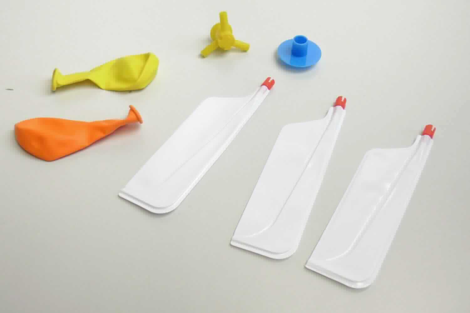 Bei der als "Ballonhelicopter, PP651" bezeichneten Ware handelt sich um einen Bausatz für einen Propeller, bestehend aus
- einer runden Halterung aus Kunststoff mit einem Durchmesser von 
  ca. 1,3 cm und einer Länge von ca. 2,1 cm mit drei abstehenden 
  ca. 1,5 cm langen Rohren; die Halterung ist im Inneren mit einer Pfeife versehen ist,
- drei ca. 13 cm x 3,5 cm großen, rechteckigen Flügeln aus Kunststofffolie mit einer Fassung
  aus festen Kunststoffen, die auf die Rohre gesteckt werden, 
- einem Aufsatz aus Kunststoff mit einem Durchmesser von etwa 3,5 cm,
- einem Luftballon aus - lt. Produktbeschreibung - Naturkautschuk. 

Der Luftballon wird aufgeblasen und auf die Halterung gesteckt. Durch die ausströmende Luft werden die Propeller angetrieben und der Ballon fliegt pfeifend durch die Luft. Die Ware dient der spielerischen Unterhaltung von Kindern und Erwachsenen. 
Der Bausatz ist als Warenzusammenzusammenstellung mit einem weiteren Luftballon als Ersatz und mit einer Produktbeschreibung in einem Klarsichtbeutel mit Pappaufhänger für den Einzelverkauf aufgemacht.

Im Hinblick auf den Umfang und die Bedeutung in Bezug auf die Verwendung bestimmt der Propeller aus Kunststoff den Charakter der Ware.

Derartige Erzeugnisse werden zolltariflich als "anderes als in den Unterpositionen (KN) 9503 0010 bis 9503 0030 
erfasstes Spielzeug, Bausatz, aus Kunststoff" eingereiht.