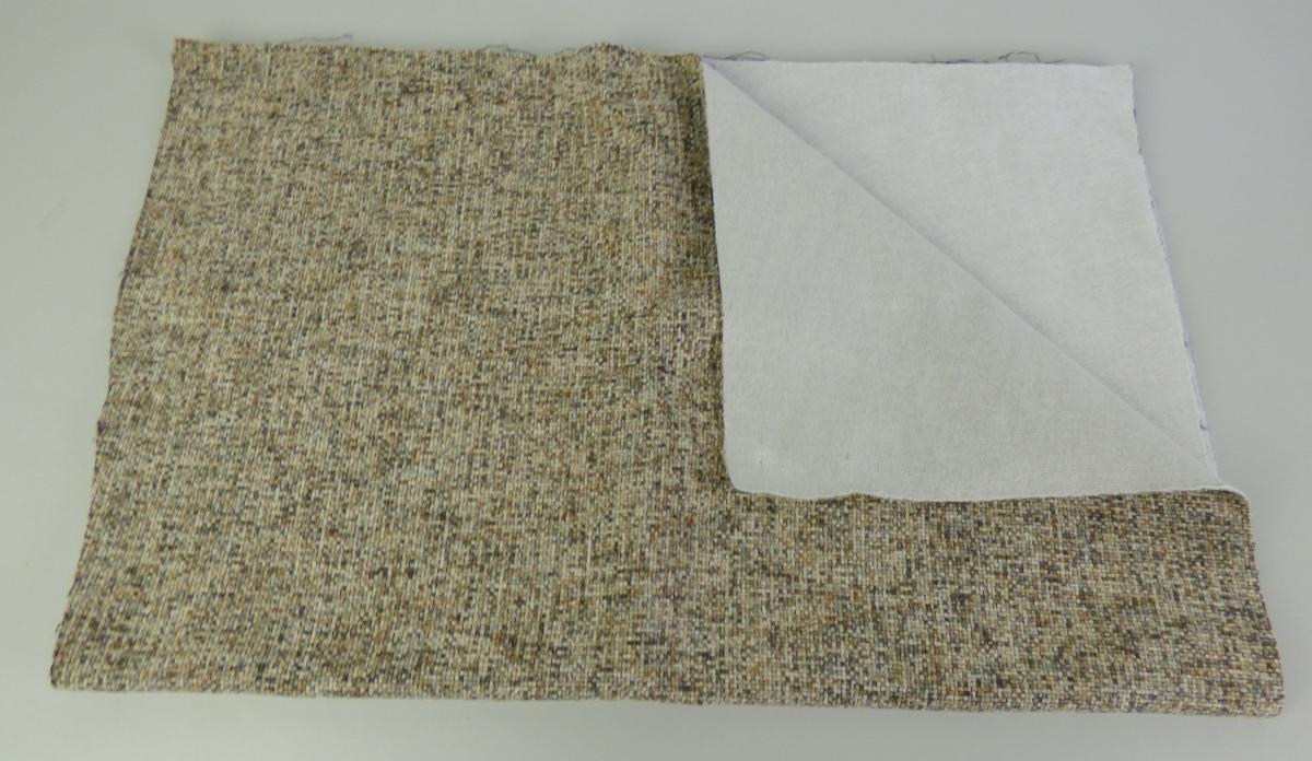 Textillaminat, sog. Möbelbezugsstoff, Art. Tetris, Foto siehe Anlage,
- als Meterware, mit einer Breite von laut Antrag 142 cm,
- aus zwei mit ihrer ganzen Fläche aufeinanderliegenden und so miteinander durch Kleben 
  verbundenen Lagen:
-- mit einer Oberlage (Schauseite):
--- aus einem Chenillegewebe, 
--- mit samtartiger Oberfläche,
--- aus Chenillegarnen und anderen Garnen; beide aus synthtischen Chemiefasern (laut Antrag
    Polyester),
-- mit einer Unterlage:
--- aus einem Gewirke,
--- aus synthetischen Chemiefasern,
- das die Schauseite bildende Chenillegewebe verleiht der Ware insbesondere im Hinblick auf die
  Verwendung als Möbelbezugsstoff ihren wesentlichen Charakter.

"Chenillegewebe, keine Ware der Positionen 5802 oder 5806, aus Chemiefasern"