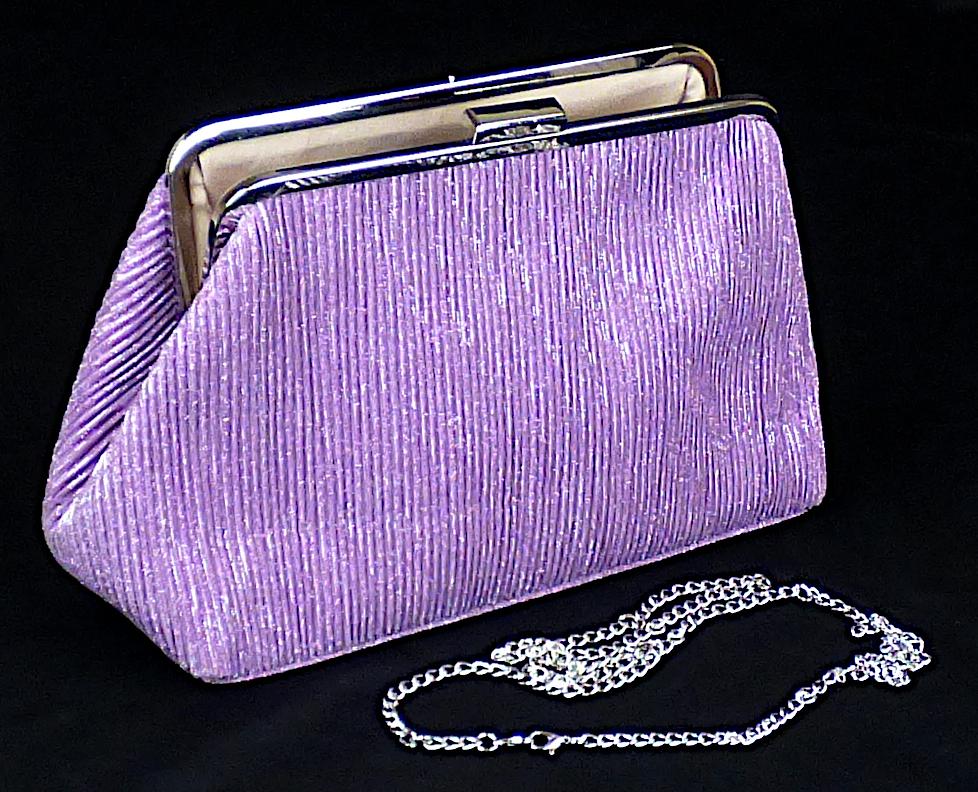 Handtasche, sog. Graceland Partytasche, JBB2360521, Foto siehe Anlage,
- mit einer Außenseite aus Spinnstoffen (Gewirke aus metallisierten Garnen),
- - musterbildend mit metallisierten Kunststoffpartikeln versehen,
- mit einem abnehmbaren Schultertrageriemen in Form einer Gliederkette aus unedlem Metall,
- mit einem Bügelverschluss versehen,
- - gefüttert; ohne Inneneinteilung,
- mit den Abmessungen: ca. 30 cm (Breite) x 19 cm (Höhe) x 10 cm (Tiefe),
- laut Antrag nicht handgearbeitet,
- Handtasche, da aufgrund der Größe und des Gesamteindrucks in erster Linie dazu geeignet,
  kleinere, persönliche Gegenstände aufzunehmen.

"Handtasche, mit Außenseite aus Spinnstoffen, nicht handgearbeitet"