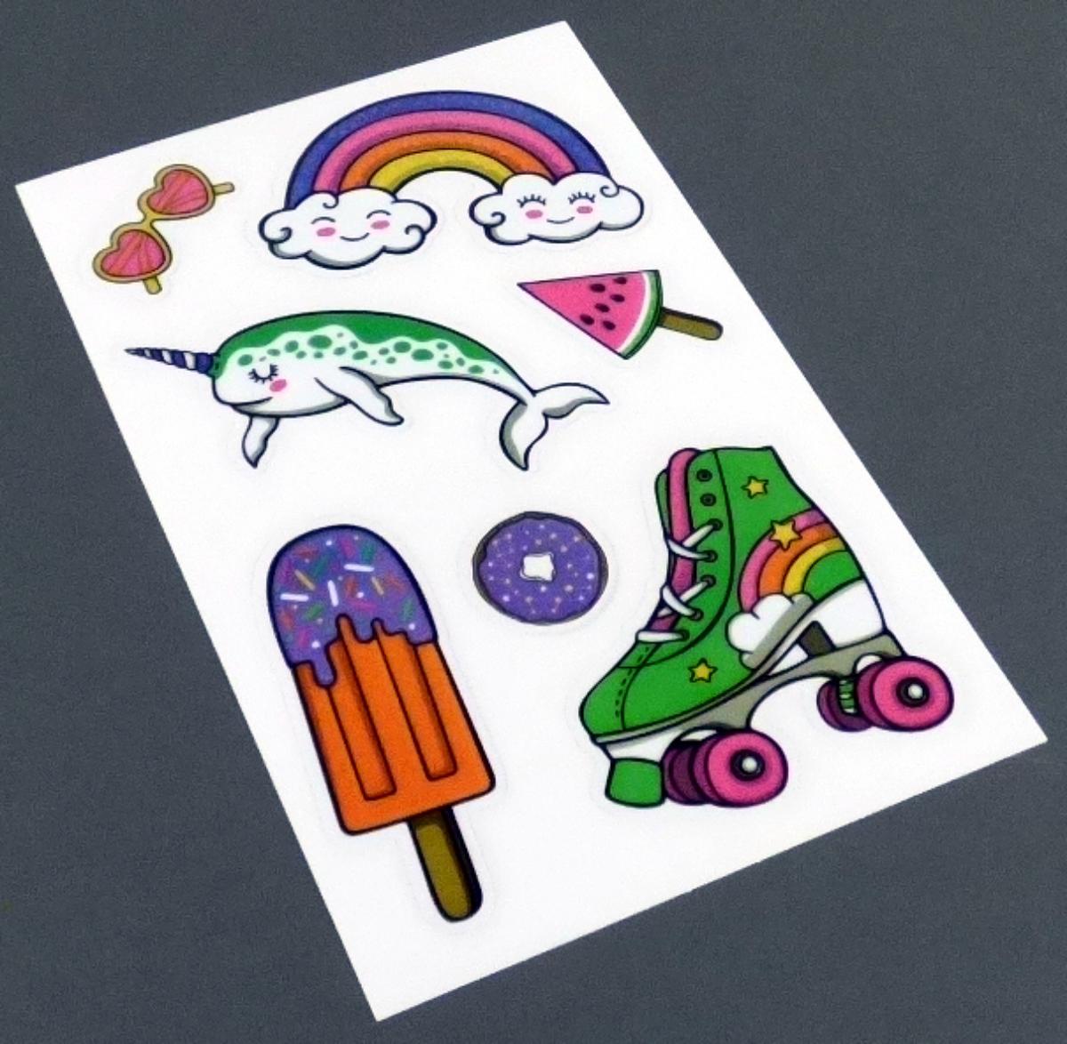 Angaben des Antragstellers:
Sticker Kids
Material: PET
Maße: 8 cm x 16 cm
Bogengröße: 8 cm x 12,5 cm

Feststellungen an einem Warenmuster:
Es wurde ein Bogen mit sieben bunt bedruckten, flachen, selbstklebenden Stickern (Eis, Sonnenbrille, Donut, etc.) aus Kunststoff vorgelegt. Die Sticker sind auf einer Schutzfolie aufgeklebt und in einem Hängebeutel mit Eurolochung verpackt.

Befund:
Es liegen selbstklebende Flacherzeugnisse aus Kunststoff im Sinne der Unterposition (KN) 3919 9080 vor.