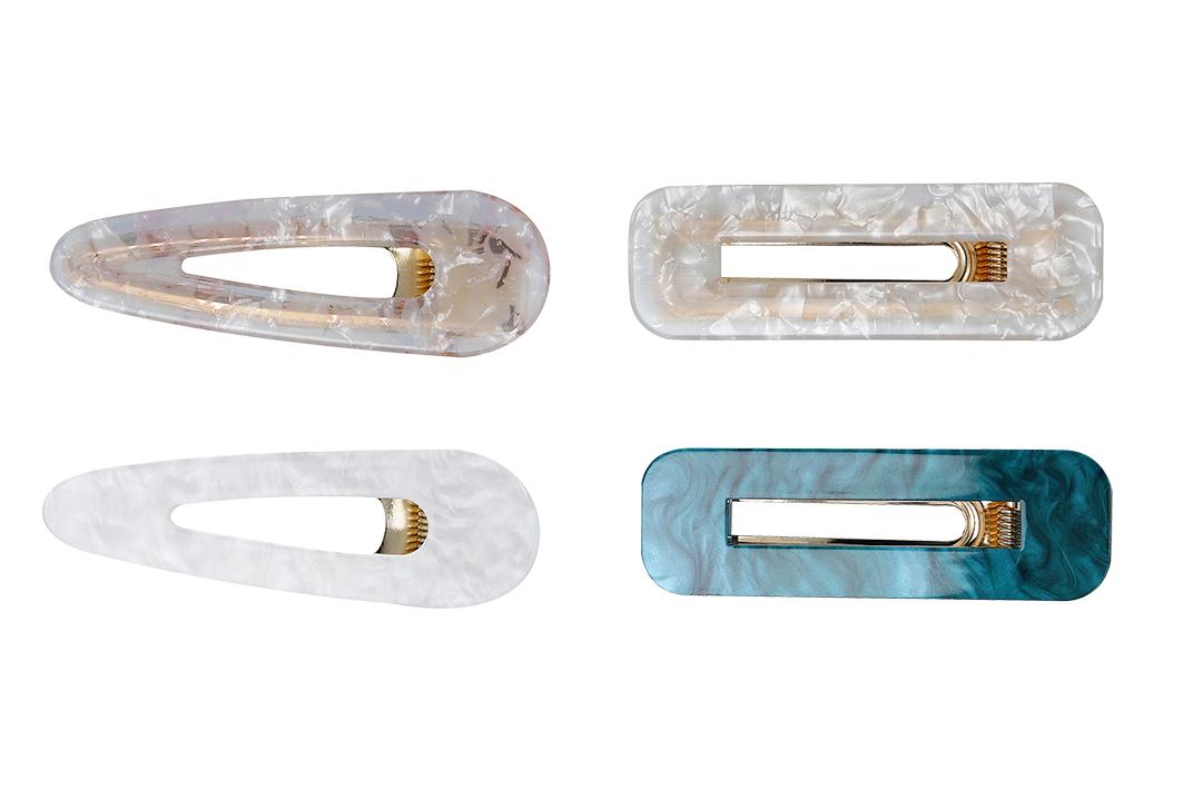 Bei der als "Haarspange CRYSTAL" bezeichneten Ware handelt es sich um ein 2er-Set von Haarspangen, jeweils bestehend aus annähernd tropfenförmigen oder rechteckigen, auf Spannung gebogenen, ca. 6,5 bis 7 cm langen Haarspangen aus unedlem Metall, mit farbigem Acrylüberzug (in verschiedenen Farben erhältlich), die mit einem Clipmechanismus (Krokodilklemme) versehen sind.

Die Haarspangen dienen dem Zusammenhalten des Haares und als Schmuck.

Die auf einer Pappkarte aufgemachte Ware ist als "Haarspange, nicht aus Hartkautschuk oder Kunststoff" einzureihen.