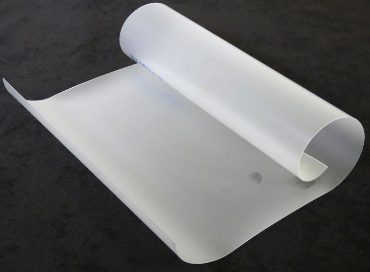 Angaben des Antragstellers:
Es handelt sich um eine thermoplastische Folie aus Polyurethan mit einer Dicke von 300 µm (+/- 18 μm). Die Ware liegt in Rollen mit einer Breite von 127 cm und einer Länge von 900 m vor und ist auf einer Seite mit einer abziehbaren Schutzfolie (Polypropylen) bezogen.

Feststellungen an einem Warenmuster:
Es wurde ein rechteckiger Abschnitt einer farblosen, leicht milchigen, nicht selbstklebenden Folie vorgelegt, welche einseitig mit einer Schutzfolie versehen ist. Die Oberseite der Folie ist matt und die Unterseite ist glänzend.

Befund:
Es handelt sich um eine thermoplastische Folie aus Polyurethan mit einer Dicke von 250 μm oder mehr, jedoch nicht mehr als 350 μm, die auf einer Seite mit einer abziehbaren Schutzfolie bezogen ist.