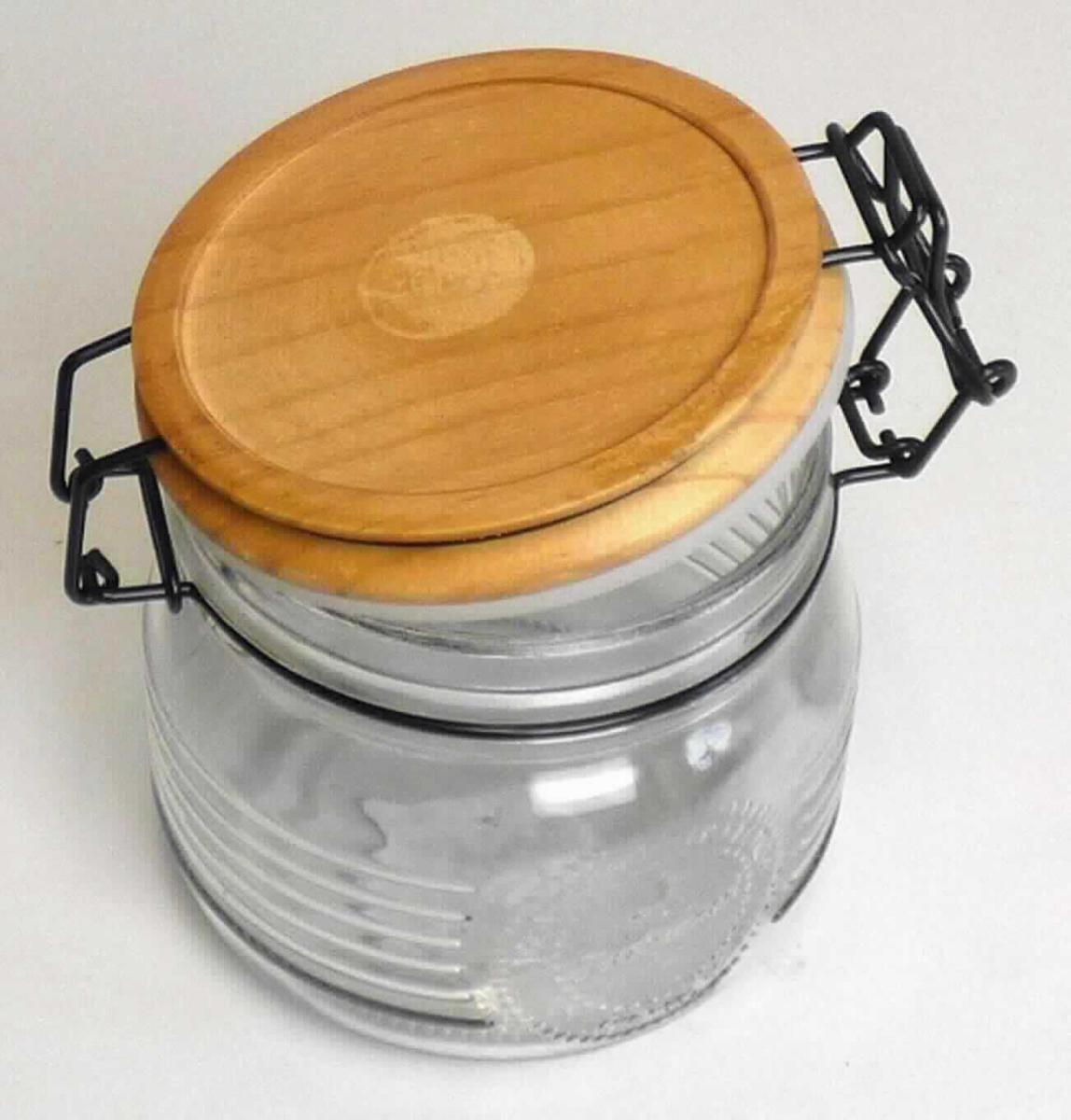 Behältnis aus Glas, sog. Vorratsglas mit Bügelverschluss, Artikel-Nr. 19540, Foto siehe Anlage,
- zusammengesetzte Ware; bestehend aus: 
- - einem oben offenen Behältnis aus klarsichtigem Glas (nicht aus Glasröhren hergestellt),
- - - mit einem Durchmesser von ca. 10,5 cm und einer Höhe von ca. 11 cm,
- - - mit einem Nenninhalt von 500 ml (laut Antrag),
- - einem Bügelverschluss aus unedlem Metall,
- - einem Deckel aus Holz,
- - einer Dichtung aus Kunststoff,
- zur Aufnahme von Nahrungsmitteln bestimmt,
- das Glas verleiht der zusammengesetzten Ware nach dem Umfang und im Hinblick auf die 
  Verwendung den wesentlichen Charakter.
 
"Behältnis aus Glas, von der zu Transport- oder Verpackungszwecken verwendeten Art, kein 
Haushaltskonservenglas, nicht hergestellt aus Glasröhren, mit einem Nenninhalt von weniger als 2,5 Liter,
für Nahrungsmittel, anderes als Flaschen, mit einem Nenninhalt von 0,25 Liter oder mehr"