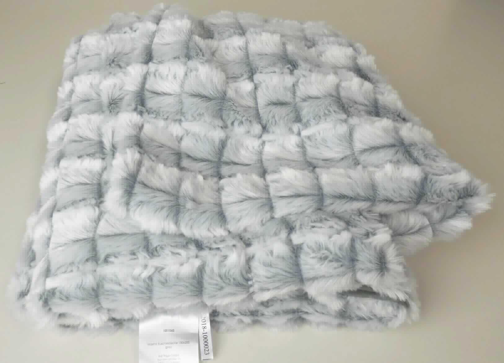 Decke, sog. "Masha" Kuscheldecke, Foto siehe Anlage,
- in einem Polybeutel verpackt,
- rechteckig, in den Abmessungen von laut Antrag: 150 cm x 200 cm,
- zweilagig gearbeitet, mit einer Lage (Schauseite) aus Plüschgewirken und einer Lage aus einfarbigen 
  Samtgewirken; beide aus laut Antrag 100 % Polyester (synthetische Chemiefasern),
- an den Rändern zusammengenäht (somit konfektioniert),
- ohne elektrische Heizvorrichtung.

"Decke, aus Spinnstoffen, ohne elektrische Heizvorrichtung, aus synthetischen Chemiefasern, aus Gewirken"