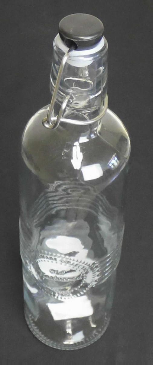 Flasche aus Glas, sog. Glasflasche Old fashioned, Artikel 19536, Foto siehe Anlage,
- aus nicht gefärbtem Glas (nicht aus Glasröhren hergestellt); etwa in der Flaschenmitte mit
  einer Rillenstruktur und einem Label verziert,
- mit einem Bügelverschluss aus unedlem Metall und einem Stopfen aus Kunststoff mit einem 
  Dichtungsring,
- mit einem Fassungsvermögen (Nenninhalt) von 730 ml,
- in den Abmessungen: ca. 7 cm (Durchmesser) x 28 cm (Höhe),
- zur Aufnahme von Nahrungsmitteln oder Getränken.

"Flasche aus Glas, zu Transport- oder Verpackungszwecken, nicht aus Glasröhren hergestellt, 
 aus nicht gefärbtem Glas, mit einem Nenninhalt von 0,730 l, für Nahrungsmittel und Getränke"