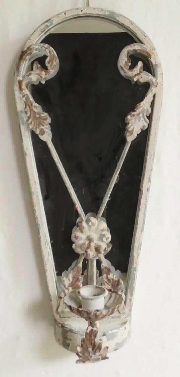 Das etwa 41 cm x 18 cm x 13,5 cm (H x B x T) große Erzeugnis ist ein Kerzenhalter in der Art eines Blakers, zur Befestigung an einer Wand. Er besteht im Wesentlichen aus einem gebogenen Rahmen aus Metall (Eisen), der mit floralen Ornamenten verziert ist, einer Rückwand aus rückseitig MDF, auf die vorderseitig ein Spiegel aufgebracht ist und am unteren Ende aus einem halbrunden Sockel aus Metall, von dem ein gebogener Schaft und ein Kerzenteller mit einer Hülse zur Aufnahme einer Stabkerze abgeht. 

Hinweise auf manuelle Fertigung liegen nicht vor.

Das Erzeugnis ist als "nicht elektrischer Beleuchtungskörper, anderweit weder genannt noch inbegriffen, nicht handgearbeitet" einzureihen.