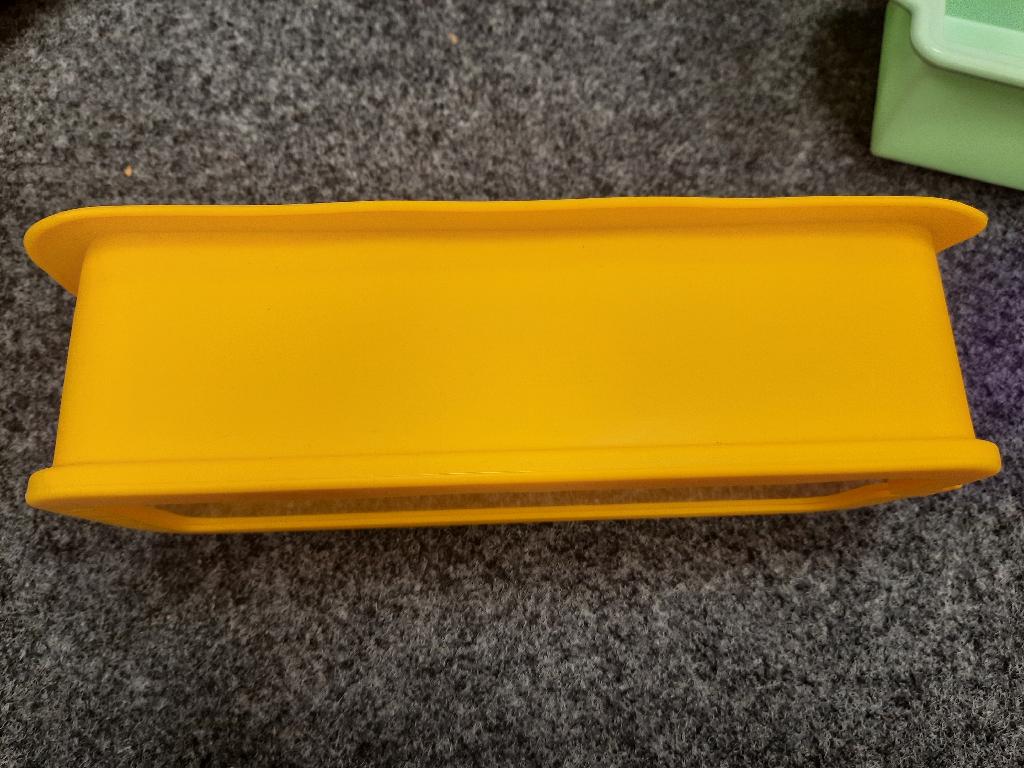 Glasware zur Verwendung in der Küche, sog. Kuchenform, Fotos siehe Anlage,
- in Form einer rechteckigen Backform (Springform),
- mit einer Bodenplatte aus klarsichtigem, laut Antrag vorgespanntem Glas,
- mit einem abnehmbaren Rand aus laut Antrag Silikon (Kunststoff), der am unteren Ende
  einen Falz zum Einsetzen der Bodenplatte aufweist,
- mit einer Manschette aus Kunststoff zum Zusammenhalten der beiden Enden des Rands,
- in den Abmessungen von ca. 28 cm (Breite) x 13 cm (Tiefe) x 7,5 cm (Höhe),
- die Platte aus Glas (Bodenplatte) kann separat als Servierplatte verwendet werden,
- das Glas bestimmt insbesondere aufgrund seiner Bedeutung in Bezug auf die Verwendung
  den wesentlichen Charakter der Ware.

"Glasware zur Verwendung in der Küche, kein Trinkglas, aus vorgespanntem Glas"