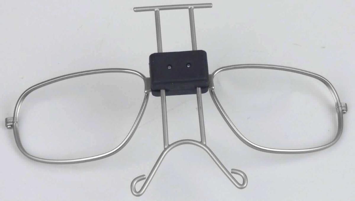 Sog. Einsatz, im Wesentlichen bestehend aus einer Fassung (ohne Bügelaufnahmevorrichtung) und einem verstellbarem Nasenaufsatz aus unedlem Metall sowie aus einem Verbindungselement aus Kunststoff (siehe Abbildung in der Anlage).
Die Fassung dient zur Aufnahme von Korrektionsgläsern und dem anschließenden Einsatz in
spezielle Schutzbrillen, welche somit als Korrektionsbrillen nutzbar sind und den Augen bei Arbeiten unterschiedlicher Art Schutz bieten. 
Das unedle Metall bestimmt im Hinblick auf den Umfang den Charakter der Ware. 
Die Fassung ist in einem Kunststoffbeutel verpackt und wird als "Brillenfassung, aus unedlen Metallen" eingereiht.