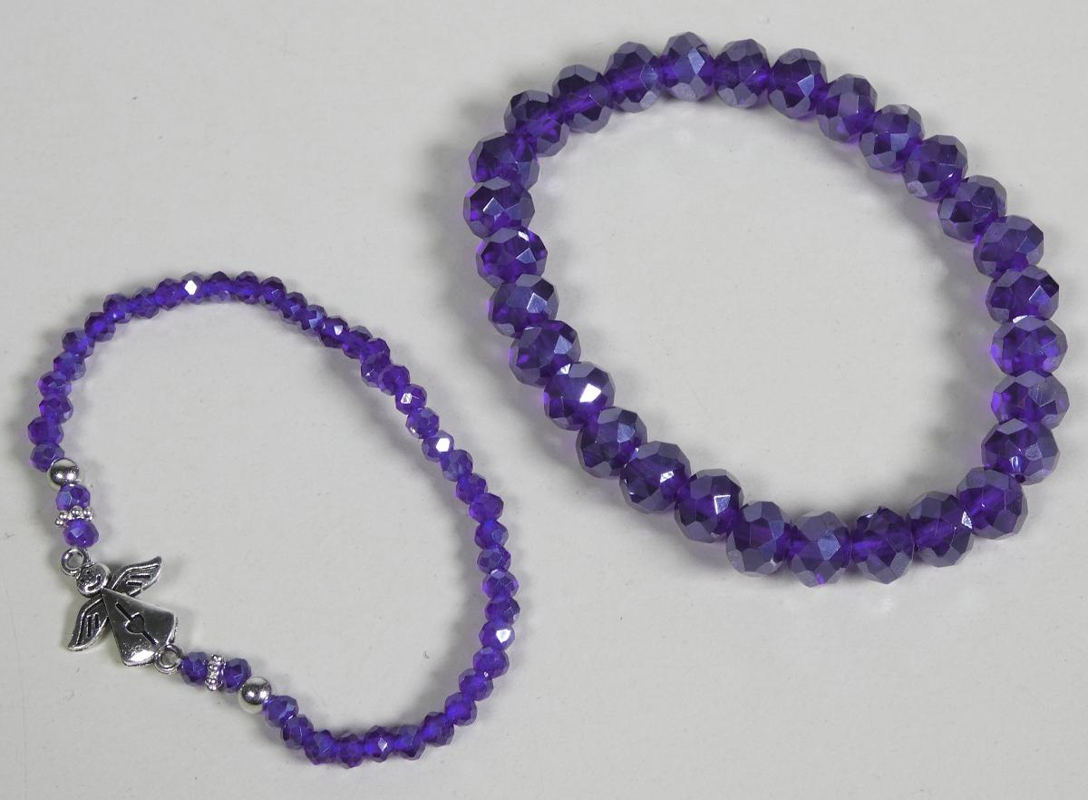 Fantasieschmuck aus Glas in Form geschlossener Armbänder aus einem elastischem Monofil (Kunststofffaden).

Angaben zur Materialbeschaffenheit sowie Größe:
1. Ein Armband (Durchmesser etwa 6 cm) vollständig aus facettierten Glasperlen in Blau.

2. Ein Armband  (Durchmesser etwa 5 cm) aus blauen facettierten Glasperlen, zusätzlich mit zwei Kugeln und zwei sternförmigen Zierteilen aus unedlem Metall. Die Elemente sind durch ein dekoratives Engelzwischenteil aus unedlem Metall verbunden. Der Engel besitzt zwei Ösen, durch die das Monofil geführt wird, wodurch das Armband geschlossen bleibt.

-Materialangaben laut Antragsteller-

Bei den aus verschiedenen Stoffen zusammengesetzten Armbändern sind die nicht metallischen Stoffe hinsichtlich ihres Umfanges und ihrer Bedeutung für die Verwendung als Schmuckware charakterbestimmend, somit das Glas.

Abbildung siehe Anlage.

Derartige Erzeugnisse gehören als "anderer Fantasieschmuck, nicht aus unedlen Metallen" zum TARIC-Code 7117 9000 00.