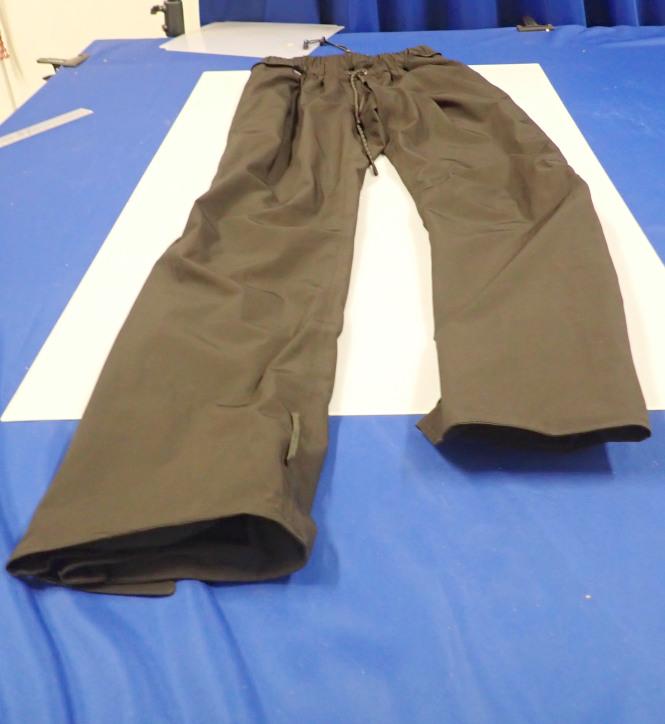 Zwei miteinander verbundene Kleidungsstücke, bestehend aus einer langen Hose aus Geweben der Kapitel 54/55 (Außenteil) und einer langen Hose aus Geweben der Position 5903 (Innenteil), sog. BÜSE Gravel XR Herren Hose, Größe L/52, Foto siehe Anlage,
- in einem Polybeutel verpackt, 
- beide Teile sind durch einen Reißverschluss und Druckknopflaschen miteinander verbunden,
  können aber auch separat getragen werden,
- lange Hose aus Geweben der Position 5903:
-- aus ca. 0,3 mm dicken, einfarbigen, einseitig (Innenseite) mit einer Folie aus Kunststoff (kein
   Zellkunststoff) laminierten Geweben der Position 5903 aus laut Antrag 100 % synthetischen
   Chemiefasern,
-- durchgehend gefüttert,
-- in der Taille abschließend; mit einem elastisch verengten Taillenbund mit Tunnelzug; mit einem 
   Verbindungsreißverschluss zur Befestigung am Außenteil,
-- ohne Öffnung und ohne Verschluss,
-- ohne Hinweise auf den Trägerkreis (unisex), somit keine Männerkleidung,
-- mit reflektierenden Aufdrucken versehen,
-- mit knöchellangen Hosenbeinen; an den Beinabschlüssen mit Klettverschlussriegeln zu verengen
   sowie mit ca. 38 cm hochreichenden Reißverschlüssen mit erweiternden Einsätzen ausgestattet.

"Kleidung (lange Hose) aus Erzeugnissen der Position 5903, aus Geweben, für Frauen"