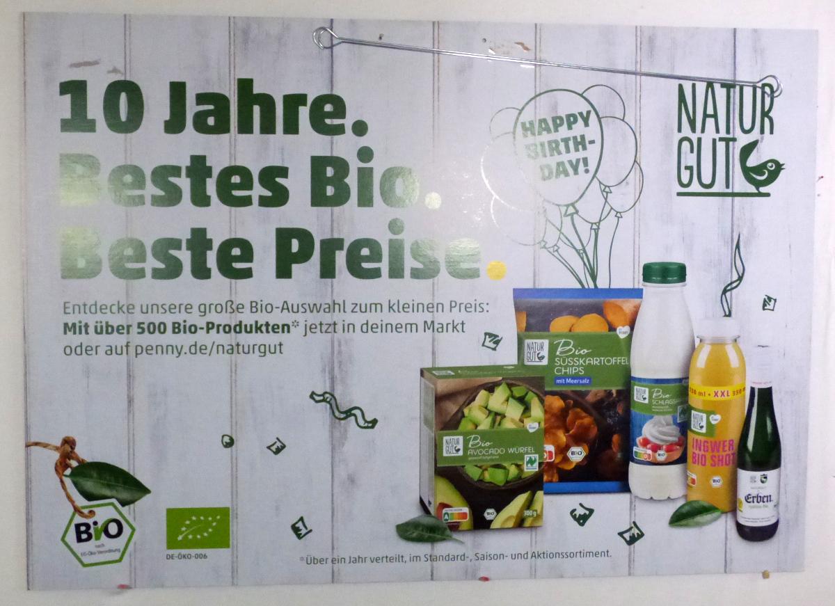 Es handelt sich um einen etwa 84 x 59 cm großen Zuschnitt aus Pappe, der beidseitig mit einem Logo, Text sowie Abbildungen von Lebensmitteln farbig bedruckt ist.  Am oberen Rand befinden sich zwei Lochungen, durch die jeweils ein Haken aus unedlem Metall gesteckt wird. Das Erzeugnis dient zu Werbezwecken und wird in Geschäften an der Decke befestigt.
Der bedruckte Pappzuschnitt ist mit zwei Haken gemeinsam für den Einzelverkauf aufgemacht.

Im Hinblick auf die Bedeutung in Bezug auf die Verwendung verleiht der Werbedruck der Warenzusammenstellung den wesentlichen Charakter.  

Abbildung siehe Anlage. 

Derartige Erzeugnisse gehören als "andere Drucke, Werbedrucke, andere als Verkaufskataloge" zur Codenummer 4911 1090 00 0 des Zolltarifs.
