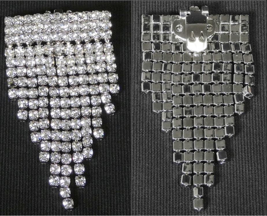 STYL GO CLIPS DECO - CRYSTAL DECO

Angaben zur Materialbeschaffenheit und Größe:
- Schuhclips aus unedlem Metall, wasserfallartig gearbeitet
- verziert mit Strasssteinchen aus Kunststoff
- auf der Rückseite eine Befestigungsclip aus unedlen Metall
- dient der Verzierung von Schuhen, Kleidern, Taschen, Hüten und ähnlichem
- Abmessungen ca. 3﻿,﻿5 x 7 cm
- weder versilbert, vergoldet oder platiniert

Es handelt sich um Zierelemente aus unedlem Metall, in die Kunststoffsteine eingefasst sind. Das Erzeugnis ist mit einem Clip aus unedlem Metall zur Befestigung an Schnürsenkeln und ähnlichem versehen und dient dem Verzieren von Schuhen. Der Schuhclip ist auf einer Pappkarte aufgebracht und in einem Polybeutel verpackt. Der Kunststoff verleiht der Ware im Hinblick auf die Bedeutung für die Verwendung (Zierwirkung) ihren wesentlichen Charakter.

Abbildung siehe Anlage.

Derartige Erzeugnisse gehören als "Phantasieschmuck, anderer als aus unedlem Metall" zum TARIC-Code 7117 9000 00.