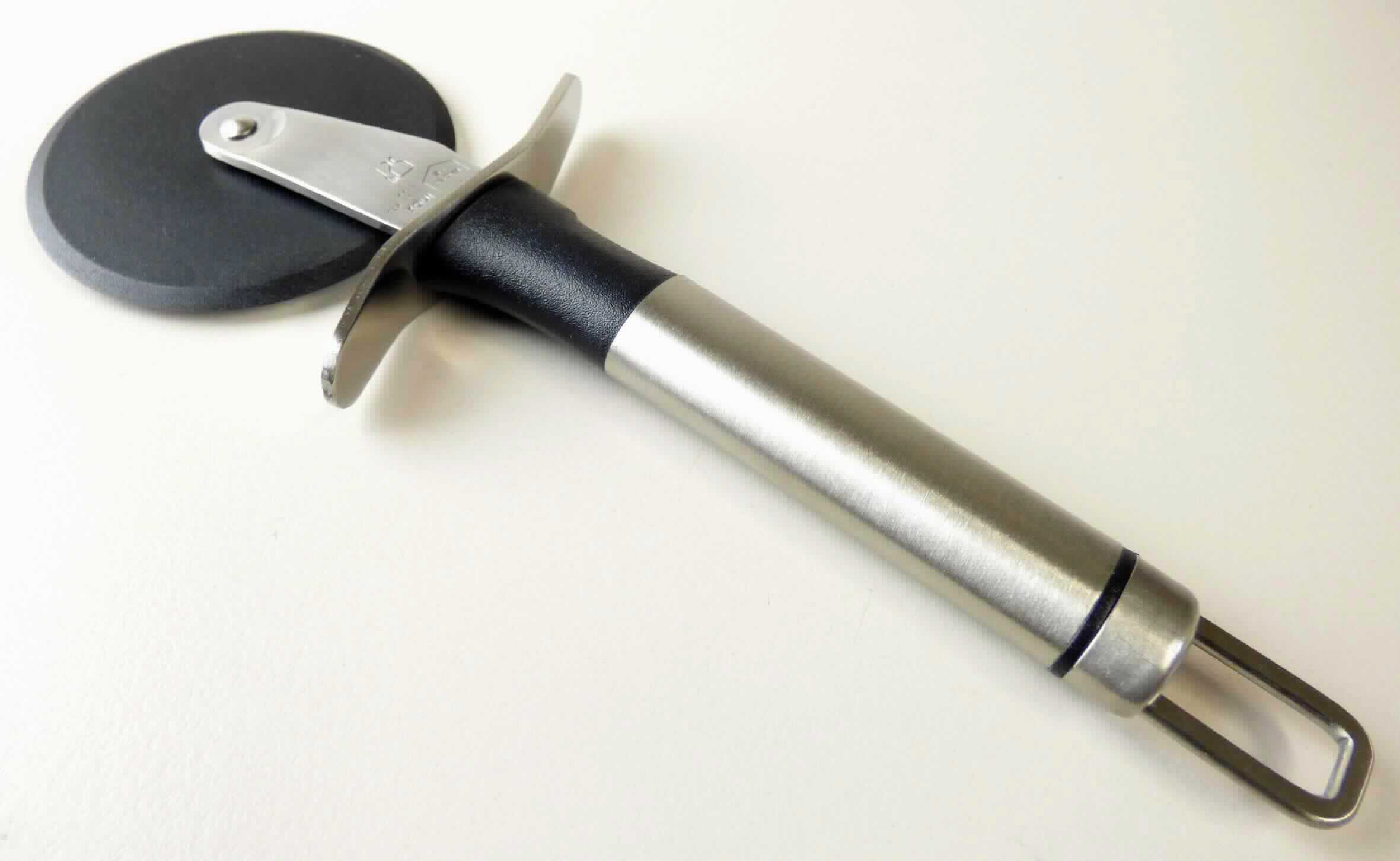Bei der Ware handelt es sich um einen Pizzaschneider mit einem kreisrunden Schneiderad aus Kunststoff im Sinne der Anmerkung 1 zu Kapitel 39 (lt. Antragsangaben Polyamid) und einer Halterung mit Griff das aus unedlem Metall, in der das Rad drehbar eingesetzt ist (lt. Produktprägung rostfreier Edelstahl). Das Erzeugnis ist auf einer aufhängbaren, bedruckten Pappkarte für den Einzelverkauf aufgemacht.

Im Hinblick auf die Bedeutung für die Verwendung bestimmt das Kunststoffschneidrad (arbeitendes Teil) den Charakter der zusammengesetzten Ware.

Der Pizzaschneider ist als "Haushaltsartikel aus Kunststoffen, Artikel für Tischgebrauch, Polyamid enthaltend, mit Herkunft in China" einzureihen.