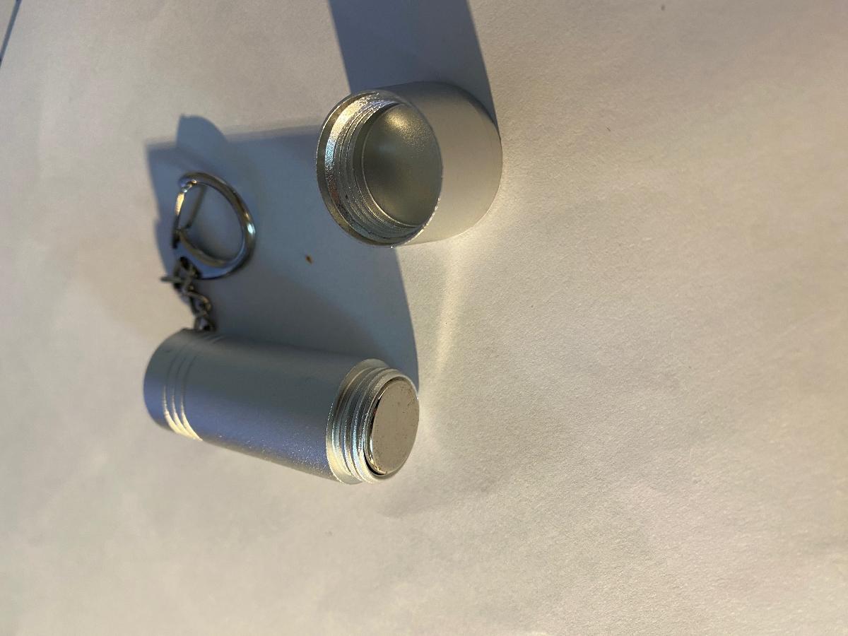Entriegler, Art.-Nr. 790644 (Abbildung siehe Anlage)
- mit einem Dauermagneten aus einer Legierung mit Eisen, Neodym, Dysprosium und Bor,
  in einem zylinderförmigen Gehäuse aus Aluminium mit abschraubbarem Deckel und
  sog. Schlüsselanhänger,
- zum magnetischen Betätigen des Metallstiftmechanismus in einer Warensicherung.
Kein Bestandteil bestimmt den Charakter des Ganzen.

"Dauermagnet aus Metall, Neodym und Dysprosium enthaltend, nicht von den TARIC-Codes
 8505 11 10 10 bis 8505 11 10 75 erfasst (zusammengesetzte Ware aus Dauermagnet und
 Gehäuse aus Aluminium ohne charakterbestimmendem Bestandteil) - Entriegler"